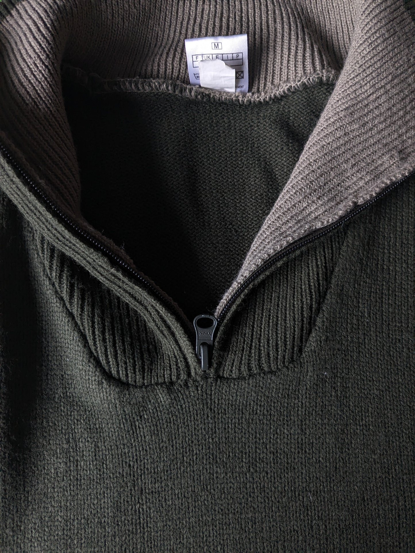 Pull de la Compagnie CSC avec fermeture éclair. De couleur vert foncé. Taille M.