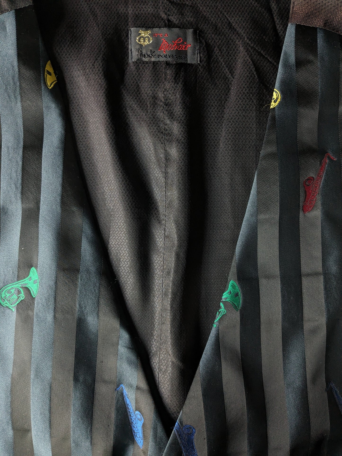 Mohair Weste. Schwarz glänzend mit farbigen Instrumenten Druck. Größe xl.