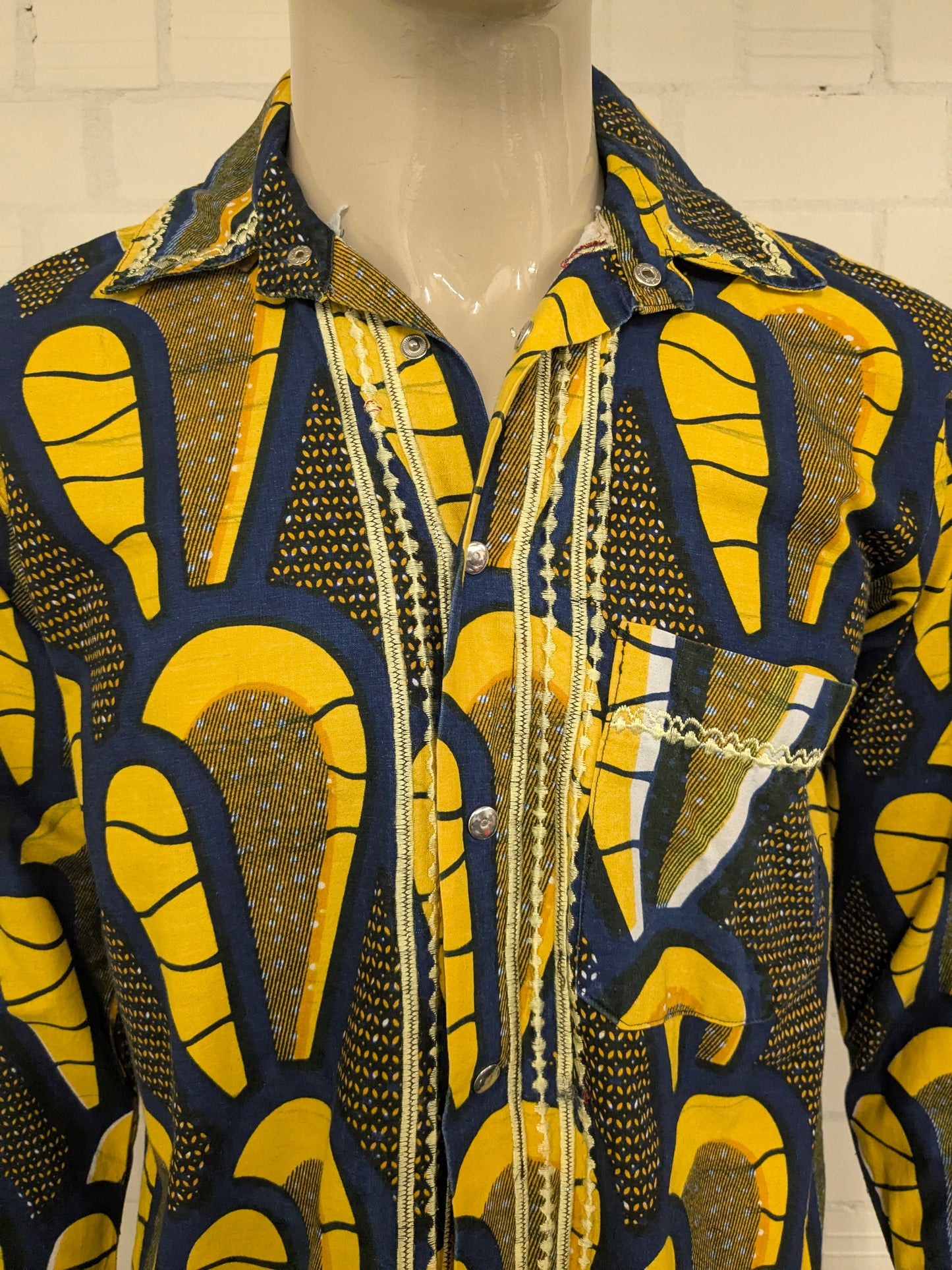 Merkloos overhemd met drukknopen. Geel Blauwe African print. Maat M.