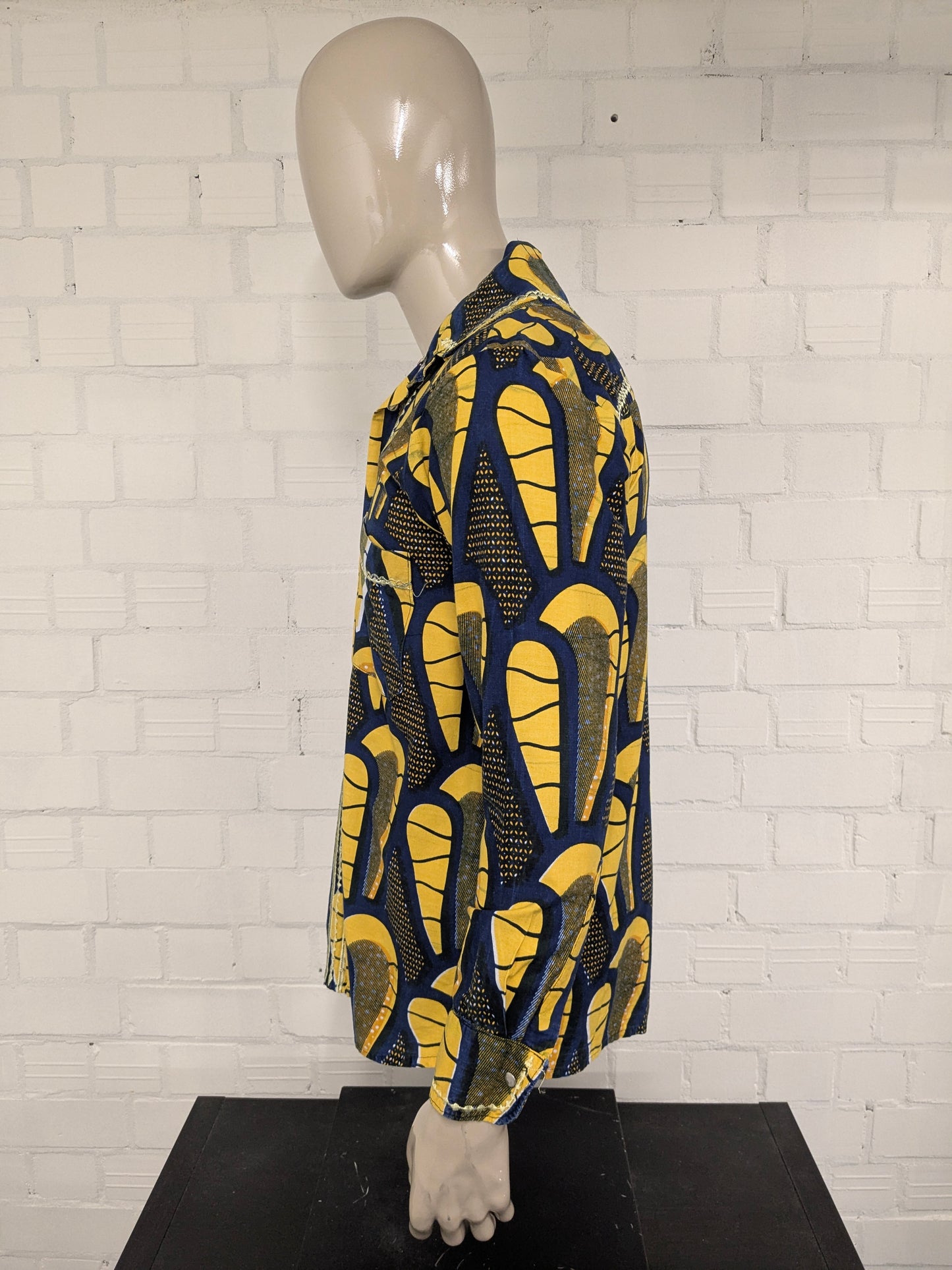 Merkloos overhemd met drukknopen. Geel Blauwe African print. Maat M.
