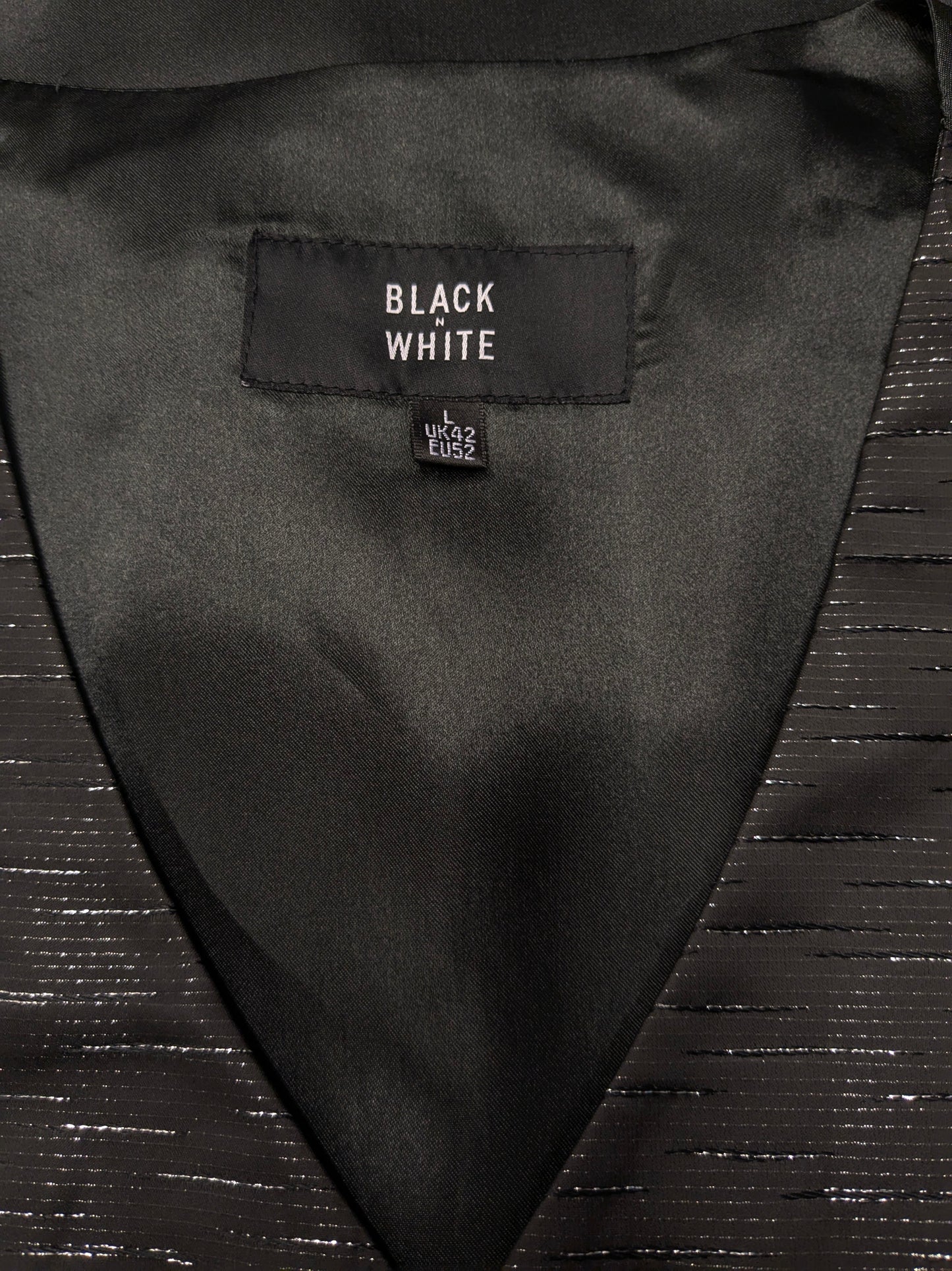 Black n white waistcoat. Black silver -colored shiny motif. Size L.