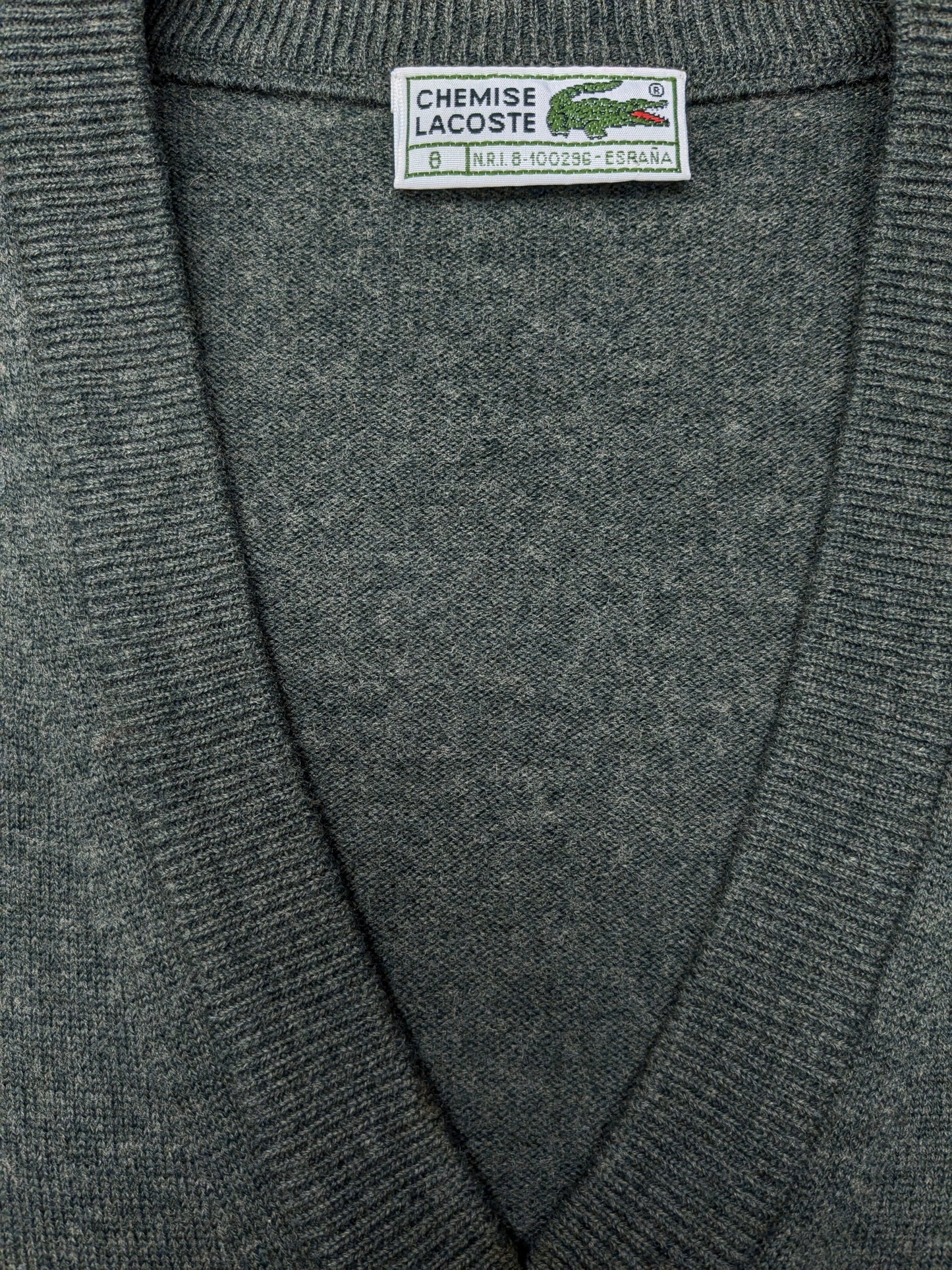 Vintage Lacoste Wollen spencer met V-Hals. Donker Grijs gemêleerd. Maat 2XL / XL. Limited Edition.