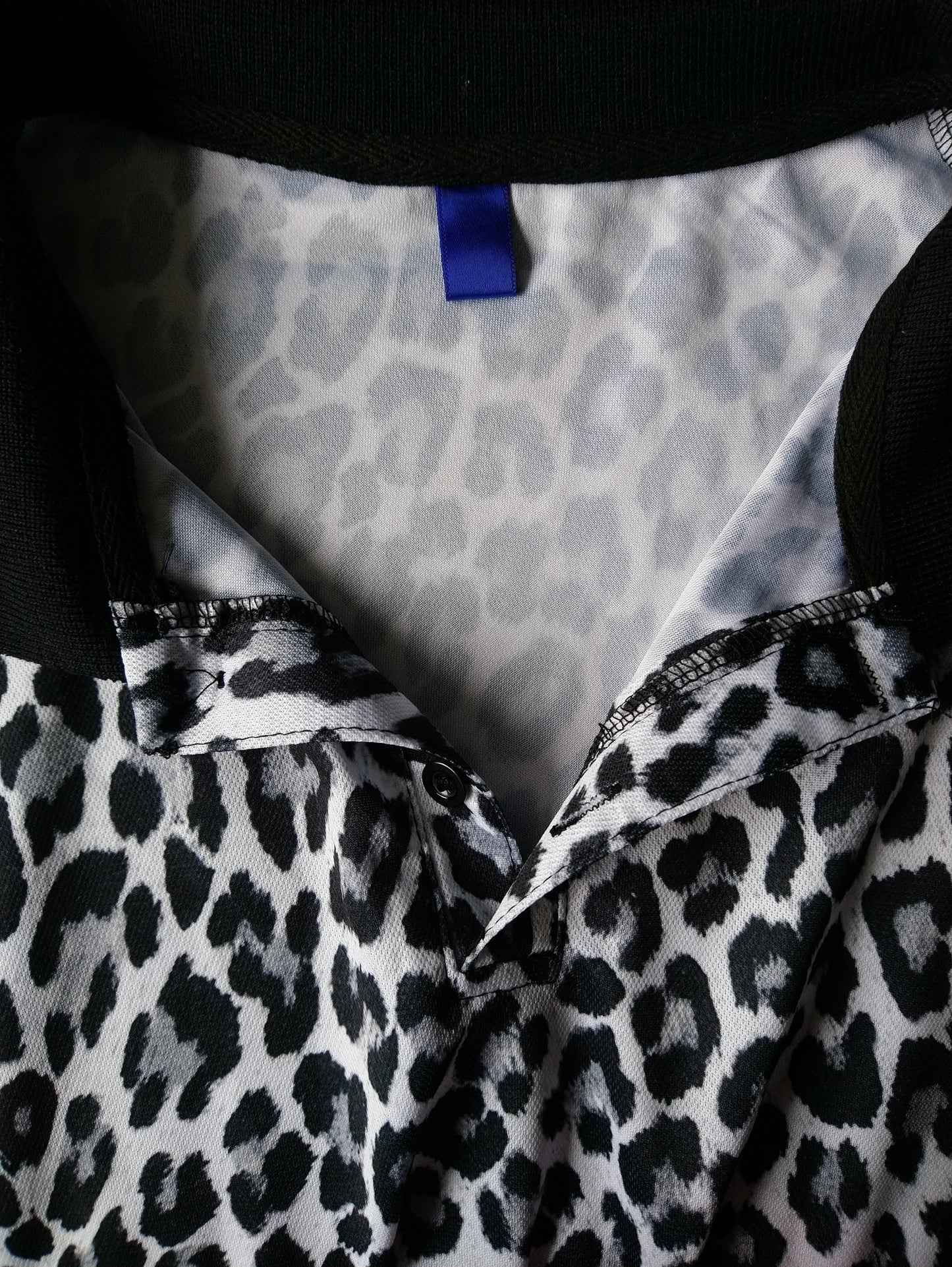 Polo avec imprimé animal. Couleur noire et blanc grise. Taille xl.
