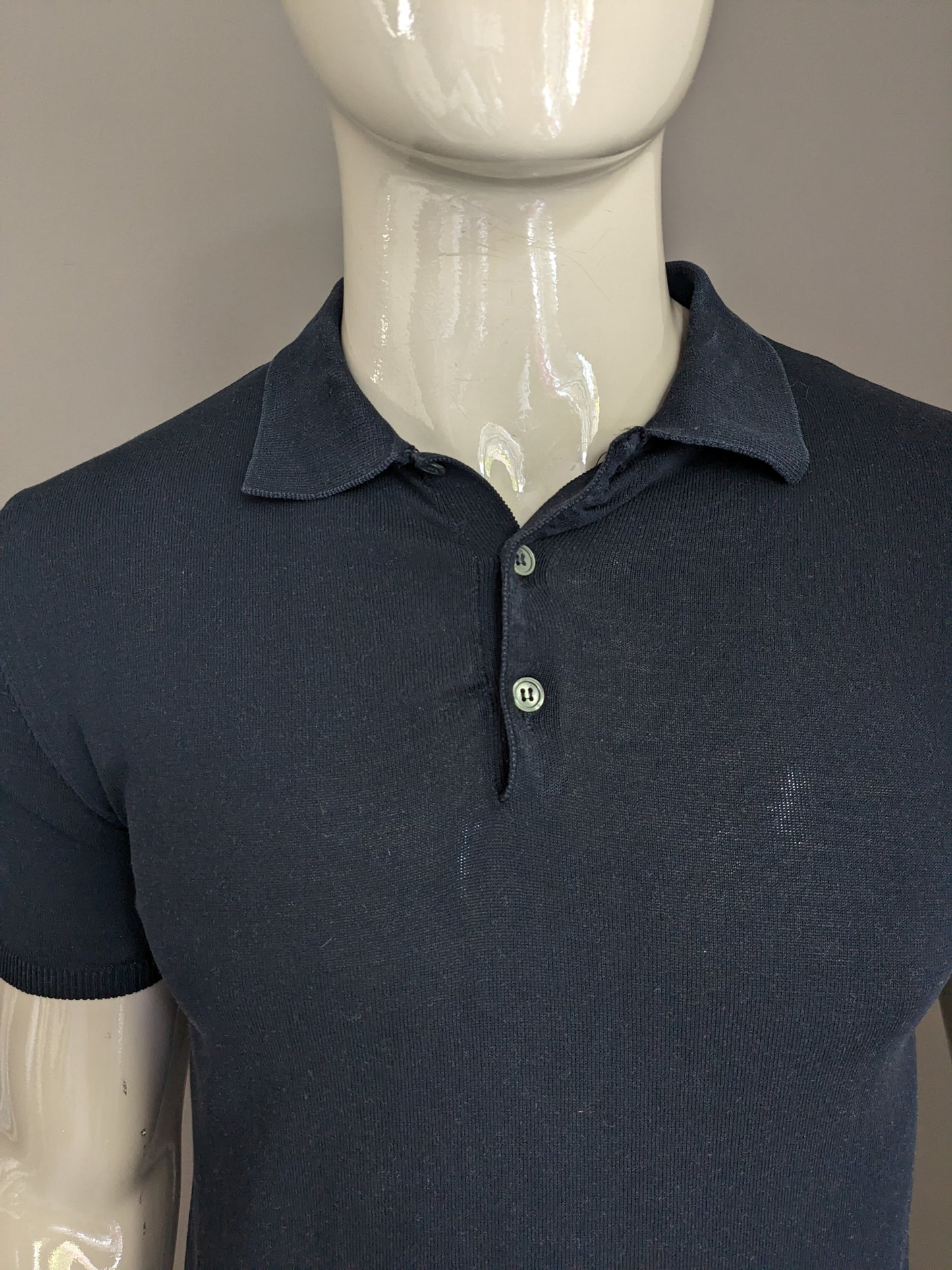 Brian Dales Polo with elastic band. Dark blue colored. Size M.