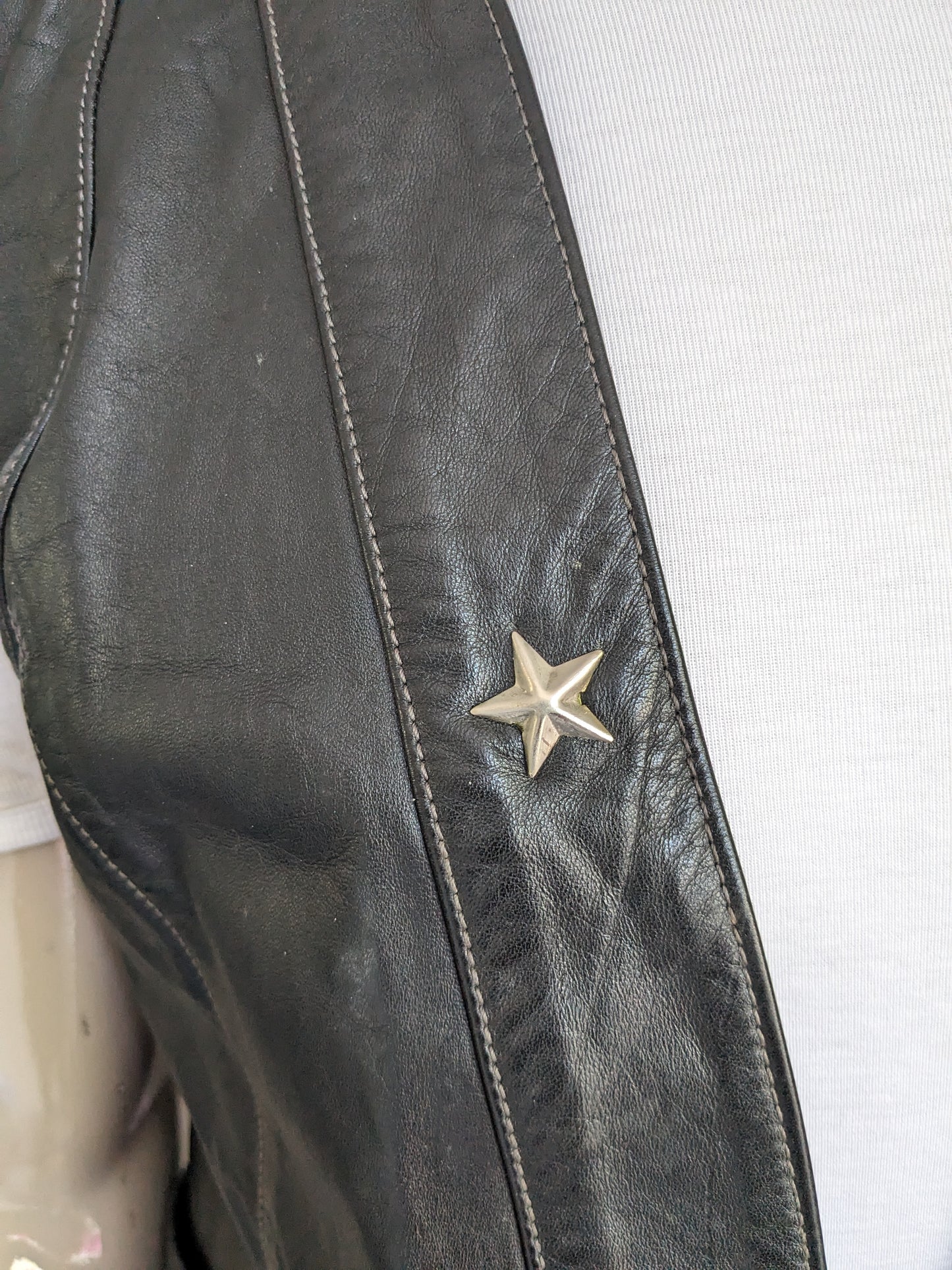 Lederweste ohne Schließung. Schwarz gefärbt mit silberfarbenem Stern. Größe M / L.