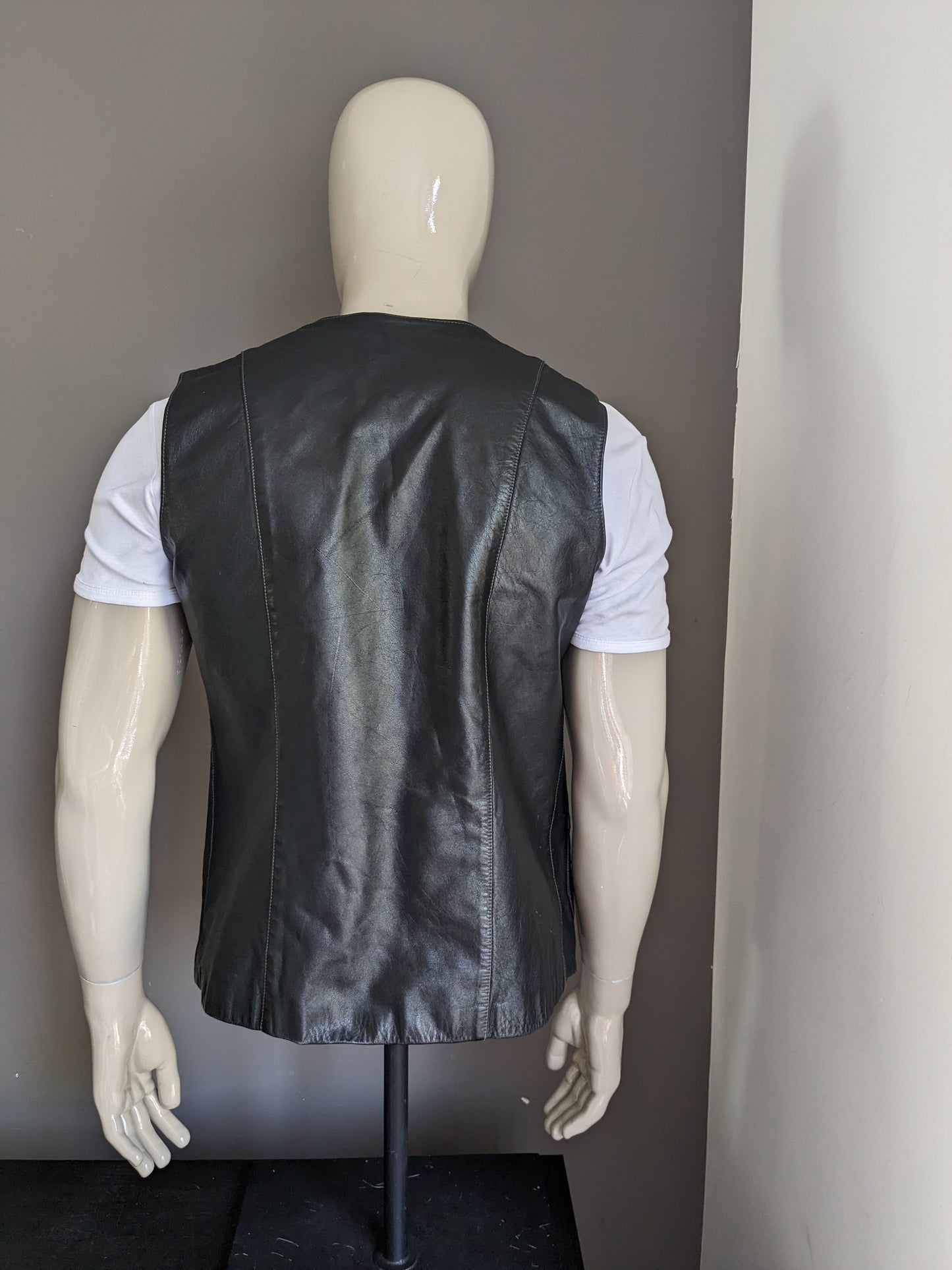 Leather waistcoat without closure. Black colored with silver colored star. Size M / L.