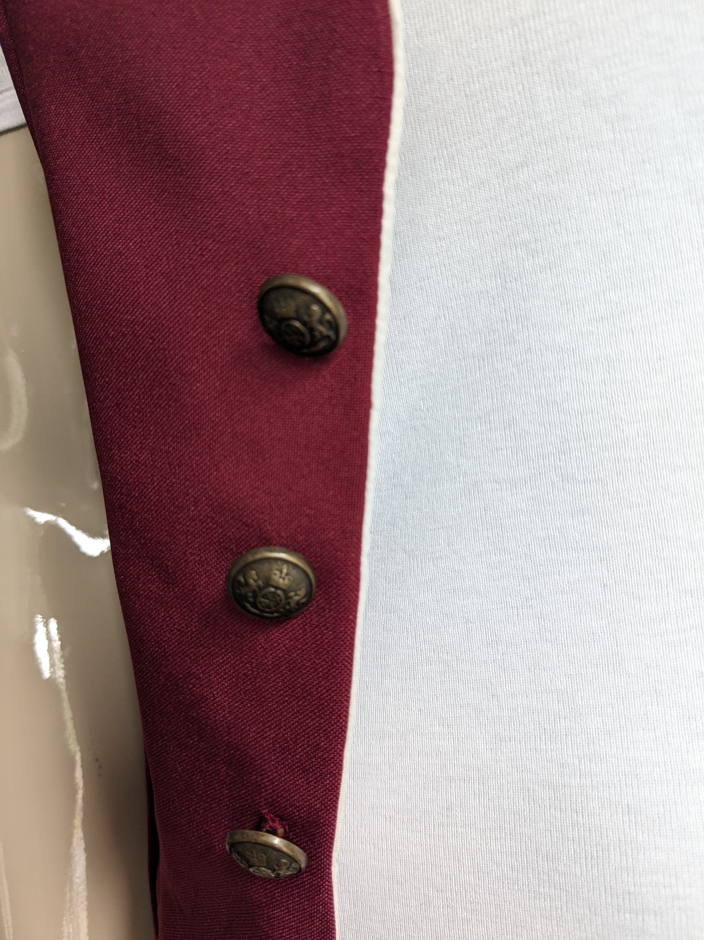 Vintage waistcoat. Bordeaux colored with beautiful buttons and unique sides. Size XS.