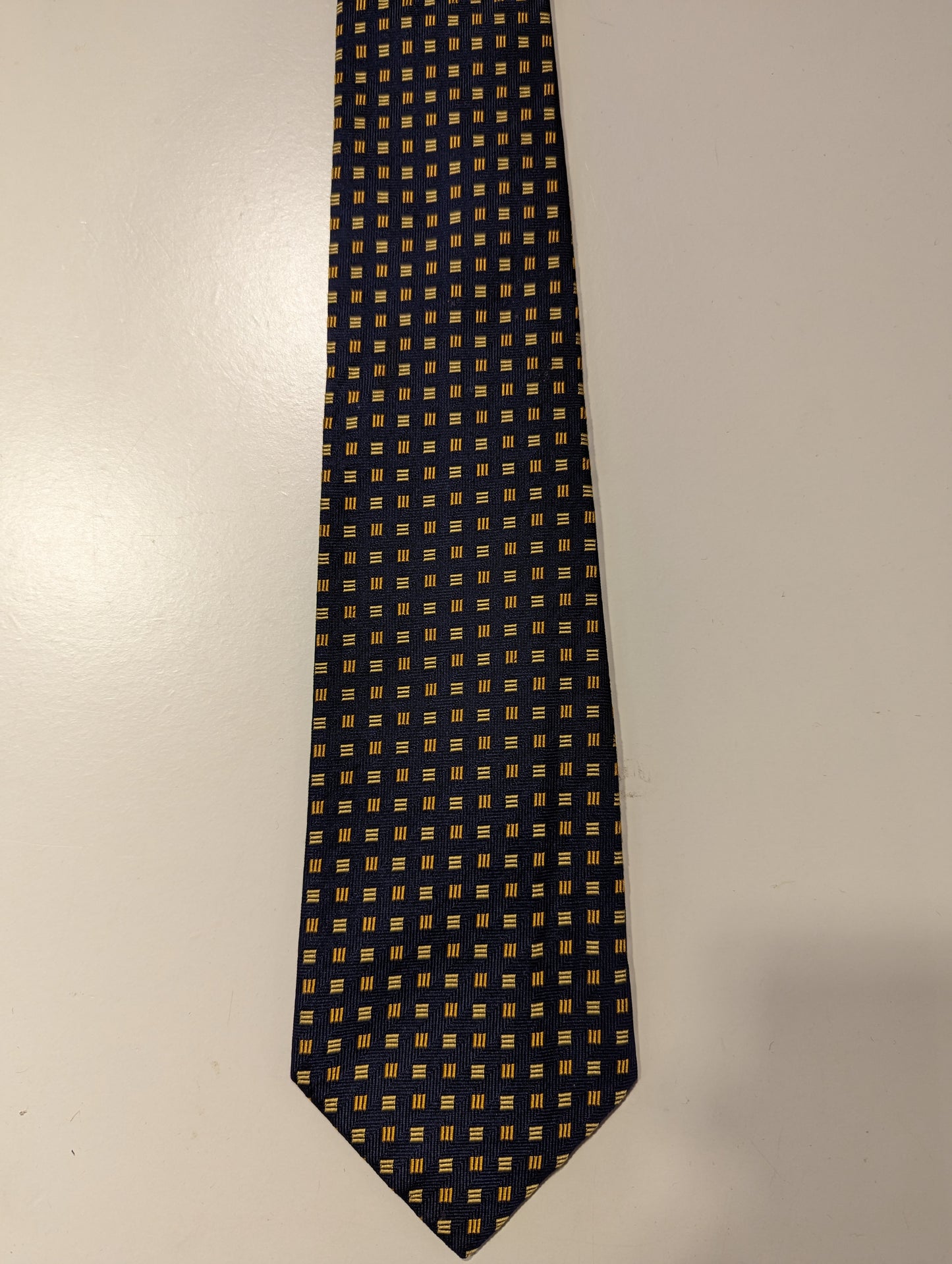La cravatta di seta inglese con cappuccio. Motivo giallo blu.