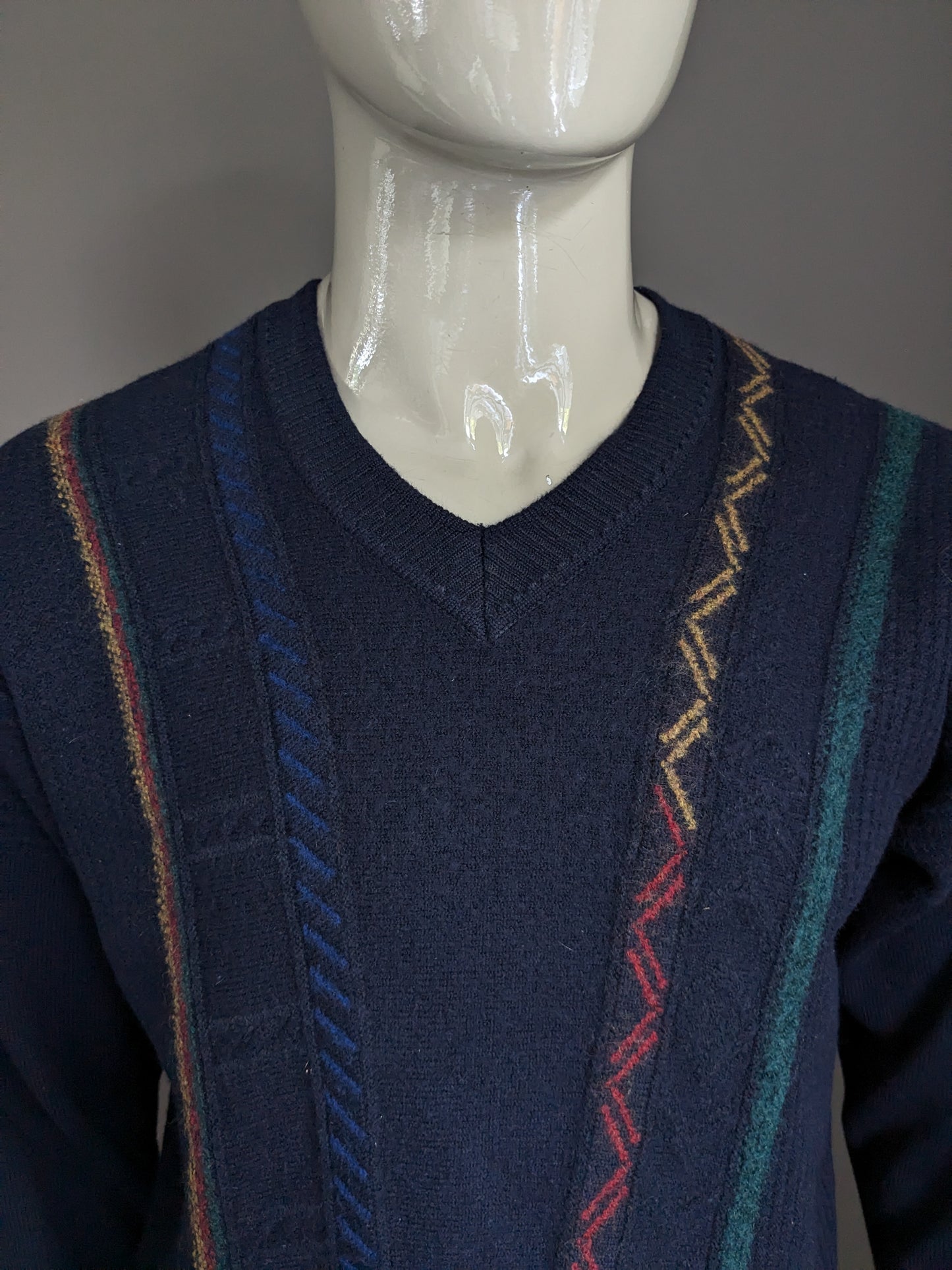 Pull vintage Maselli en laine avec col en V. Bleu foncé avec motif bleu vert rouge jaune. Taille L.