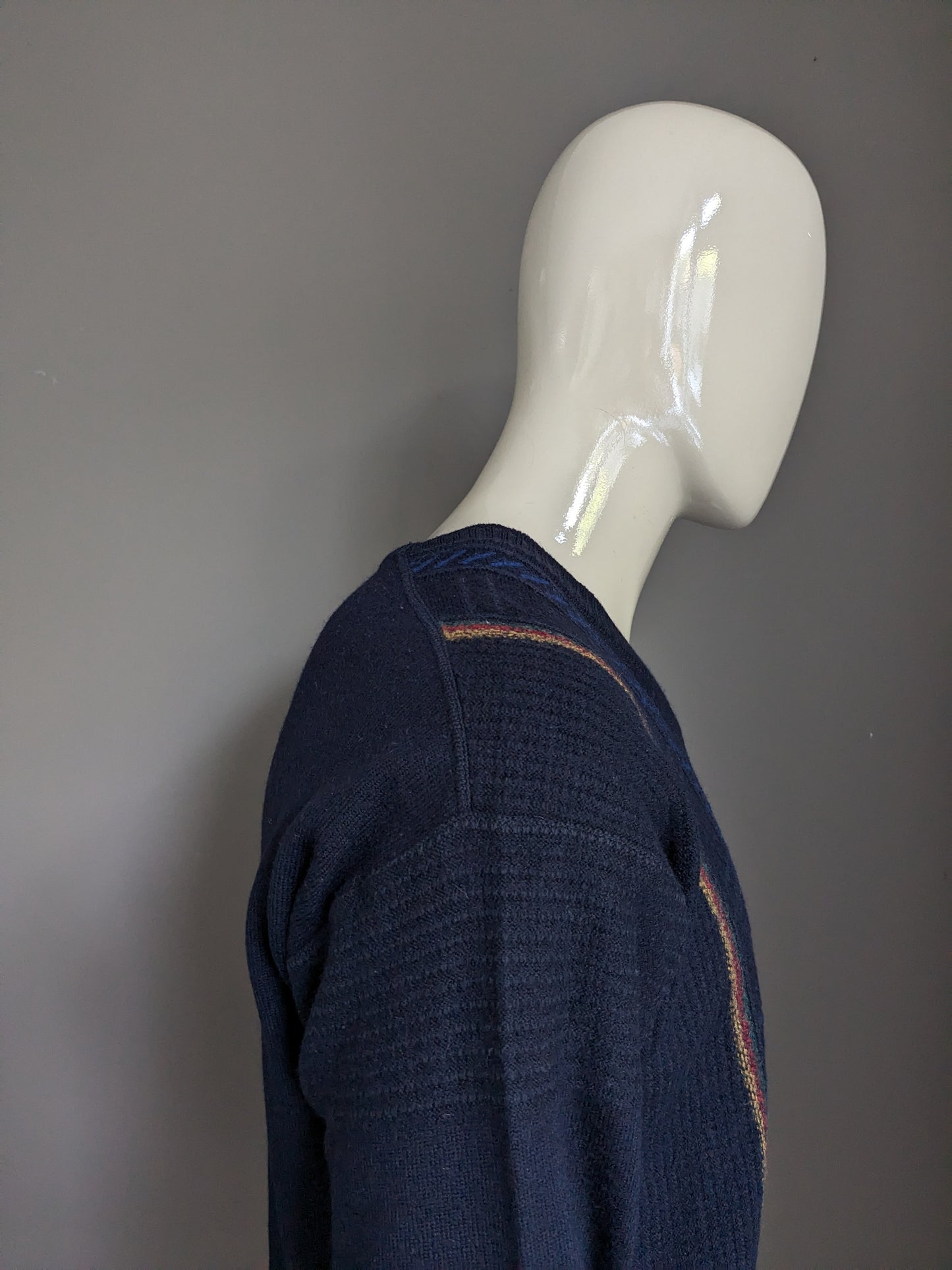 Vintage maselli wool sweater with v-neck. Dark blue with yellow red green blue motif. Size L.