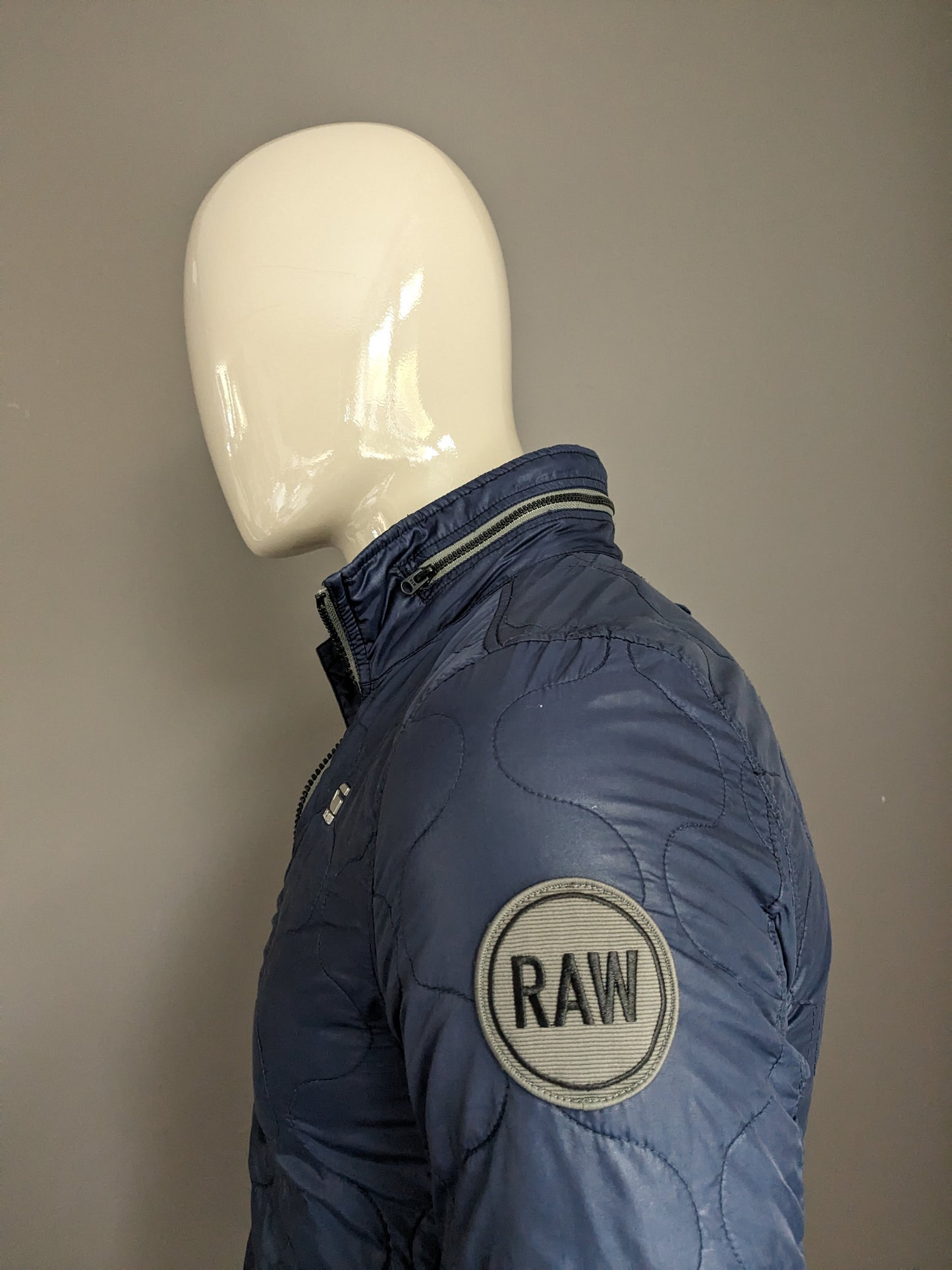 G-Star Raw licht gewicht gewatteerde jas met verborgen capuchon. Donker Blauw gekleurd. Maat S.