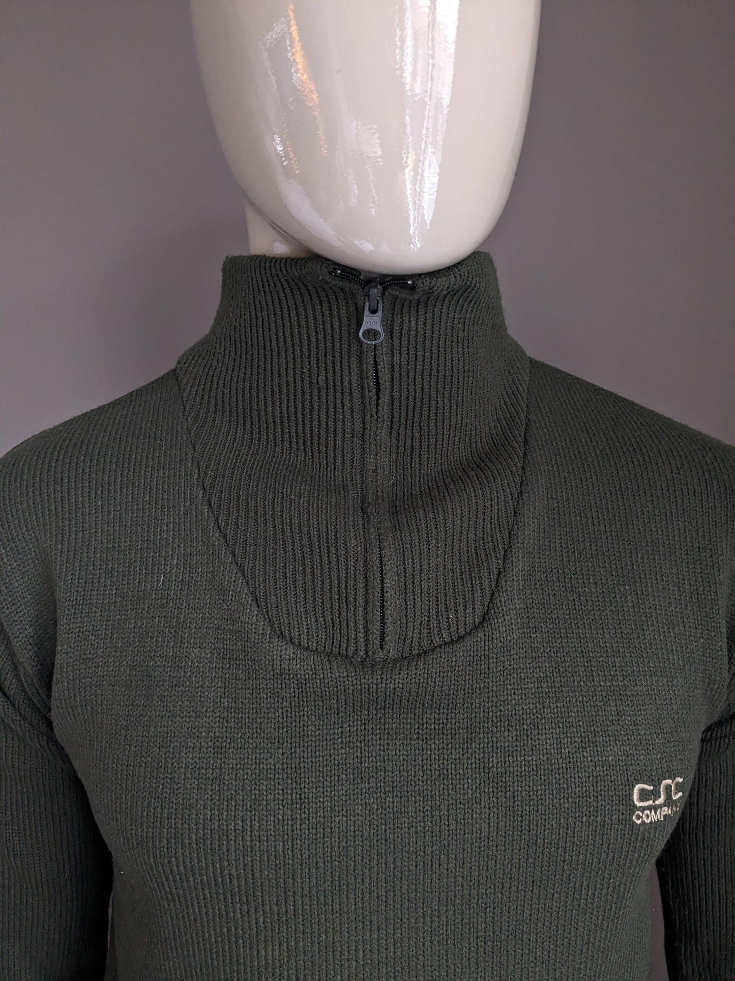 Pull de la Compagnie CSC avec fermeture éclair. De couleur vert foncé. Taille M.