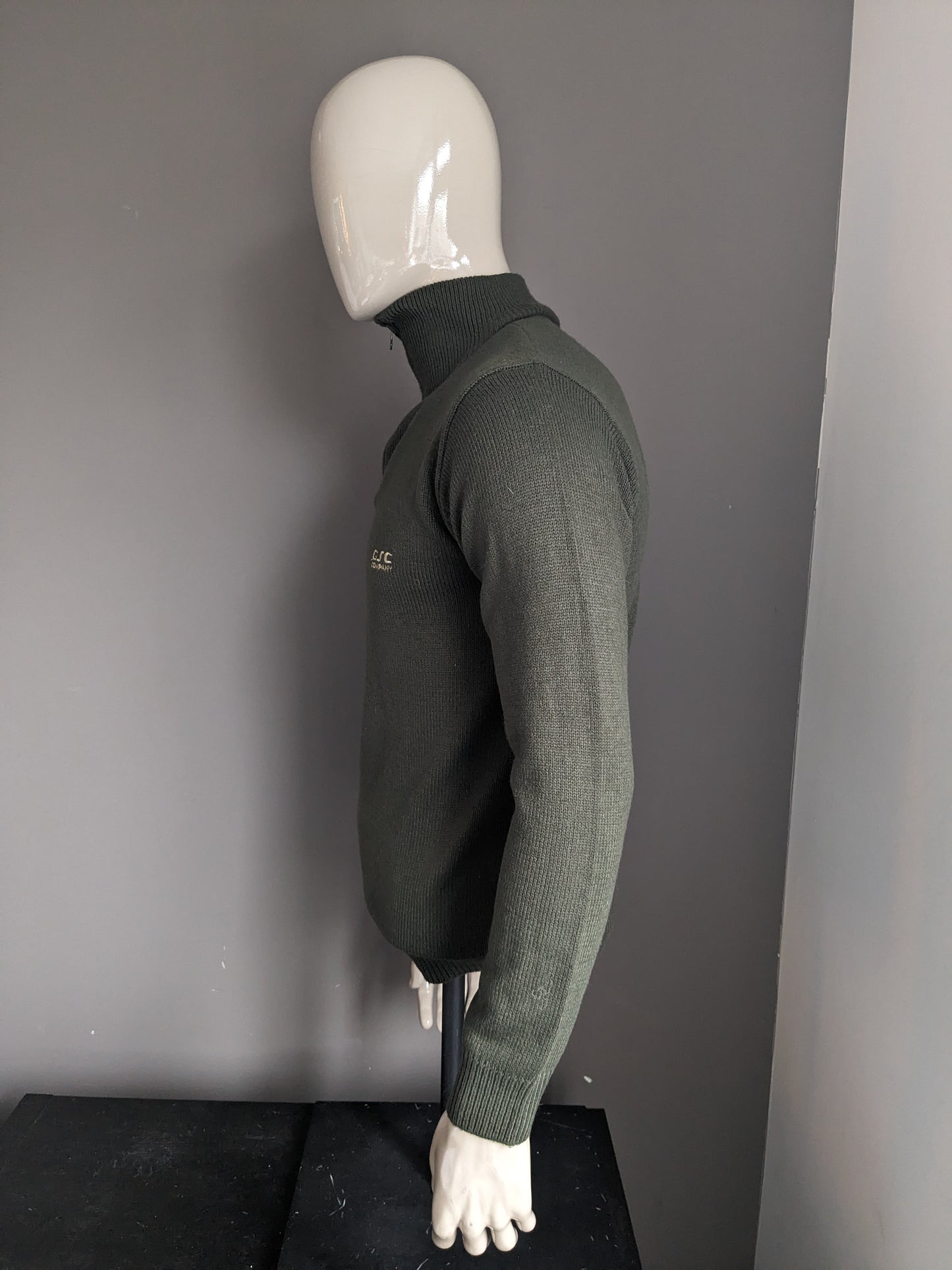 Pull de la Compagnie CSC avec fermeture éclair. De couleur vert foncé. Taille M.