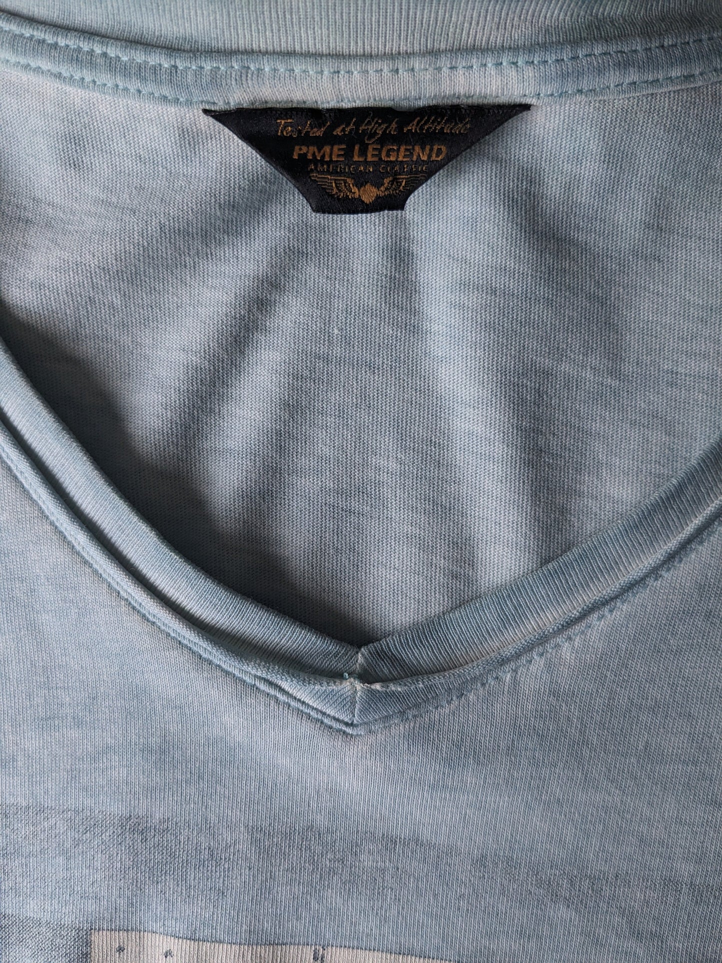 Camisa de leyenda de PME con cuello en V. Azul claro mezclado con impresión. Talla L.