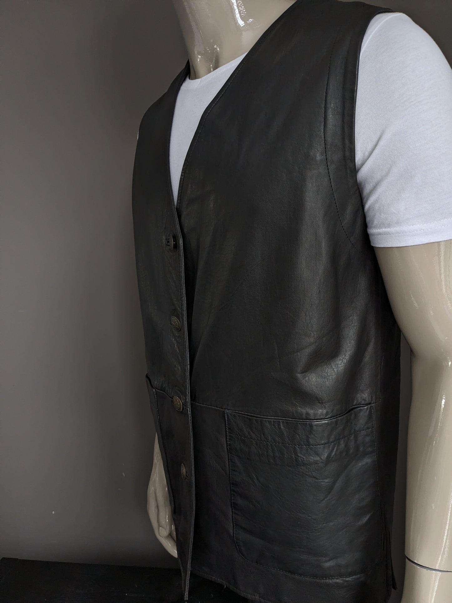 Medium length double -sided leather waistcoat with beautiful buttons. Dark brown. Size L.