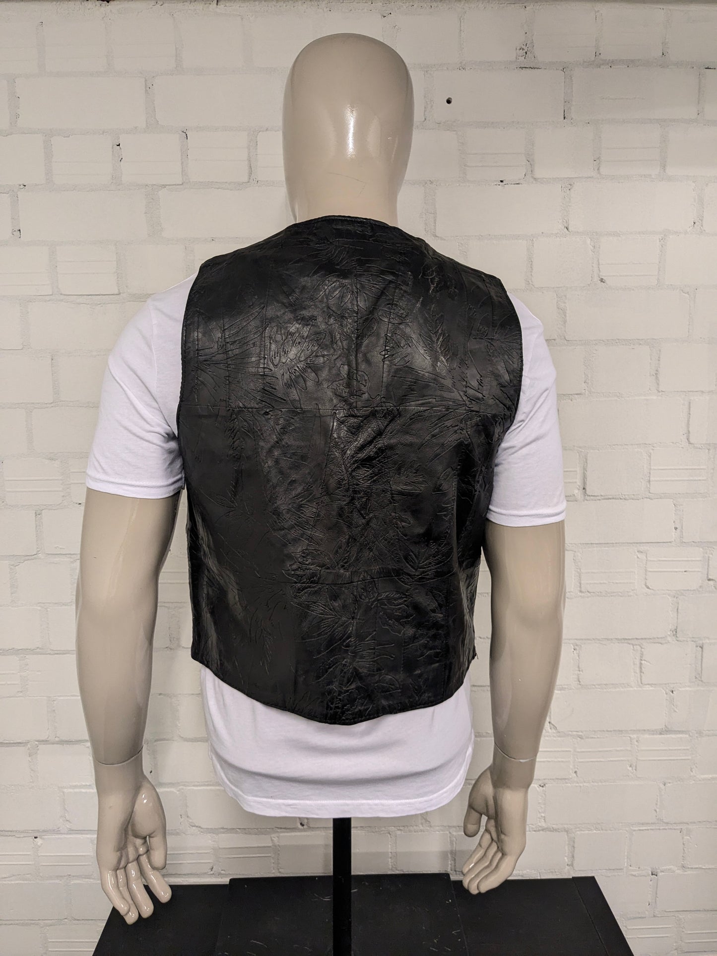 Vintage leren dubbelzijdig gilet met drukknopen. Zwart voelbaar bladmotief. Maat M.