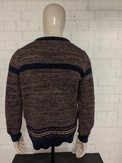 Pull en laine bleu Dansaert avec col en V. Kaki bleu rouge mélangé. Taille L. 10% de laine.