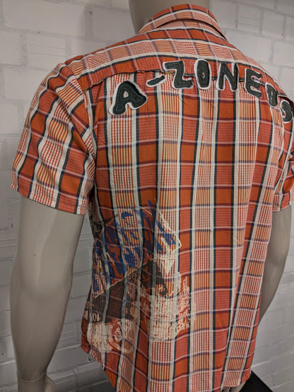 Camisa color aguamarina manga corta. Naranja Amarillo Azul marcado. con aplicaciones. Talla M.