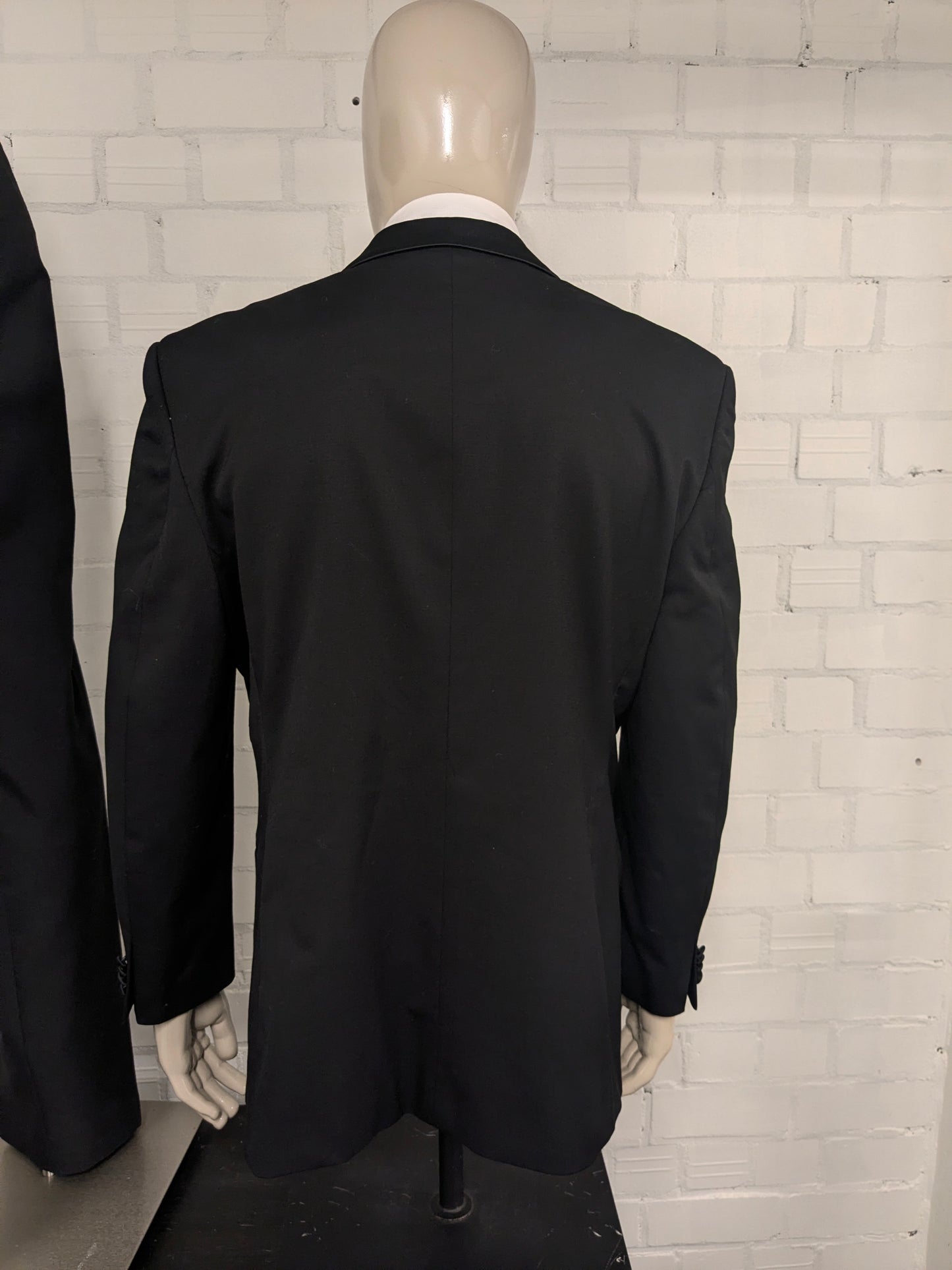 Smoking (Combinatiemaat). Zwart gekleurd. Colbert mt 26. Pantalon mt 106.