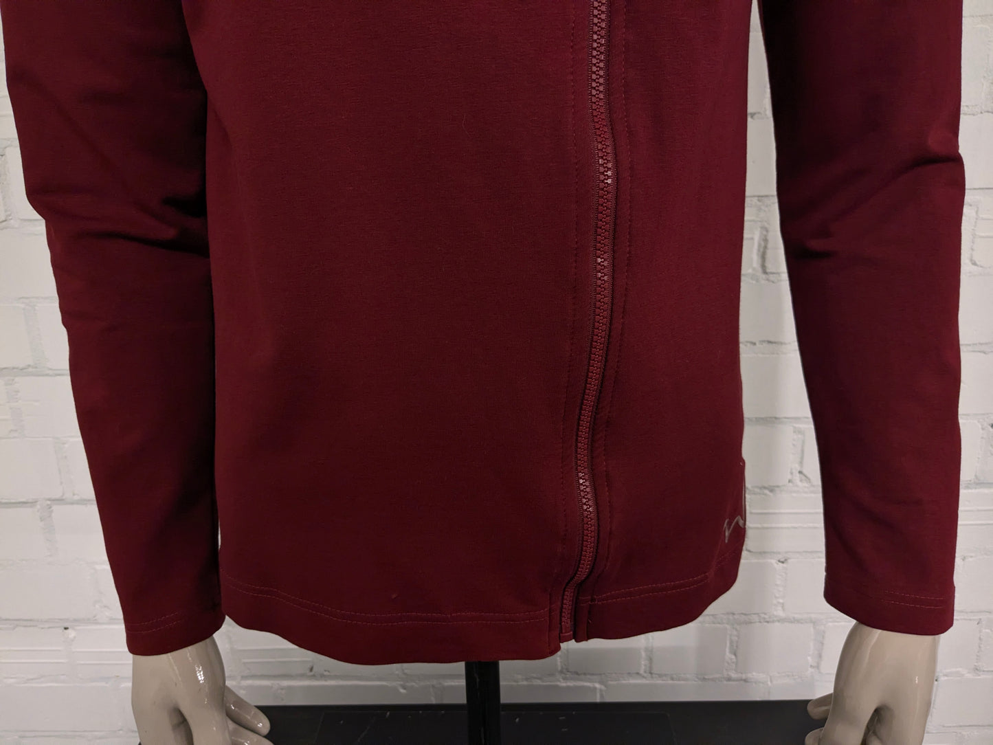 Pure White vest met capuchon en asymmetrische rits. Donker Rood gekleurd. Maat L.