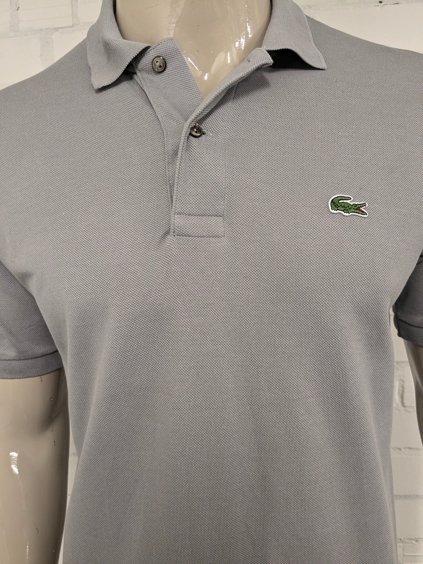Lacoste Polo. Grijs gekleurd. Maat M.