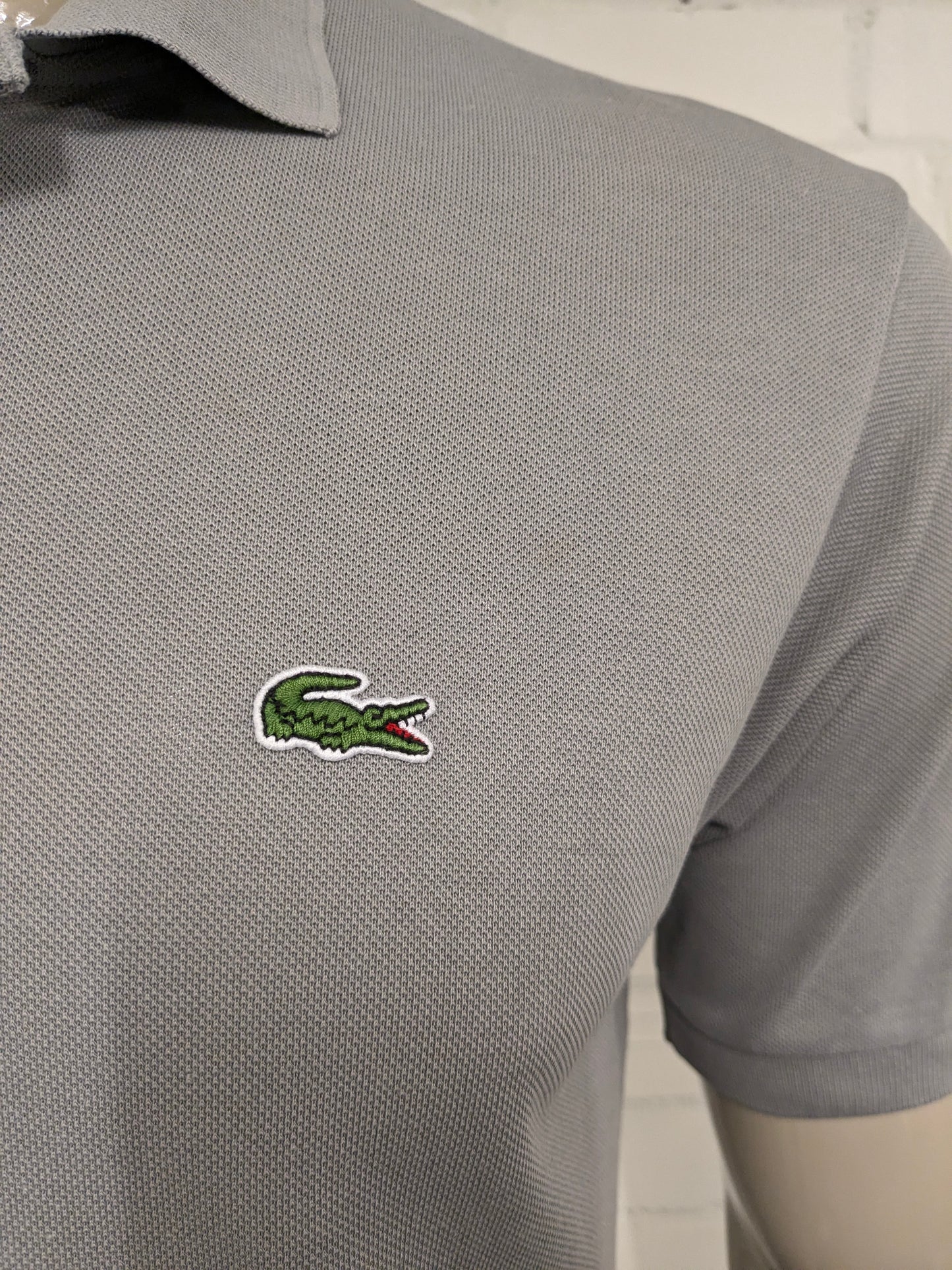 Lacoste Polo. Grijs gekleurd. Maat M.
