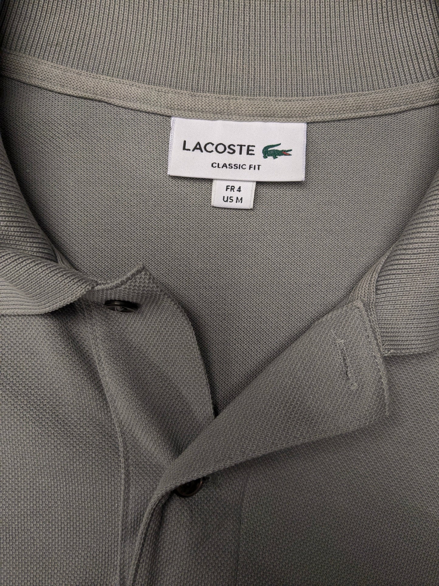 Lacoste Polo. Grijs gekleurd. Maat M.