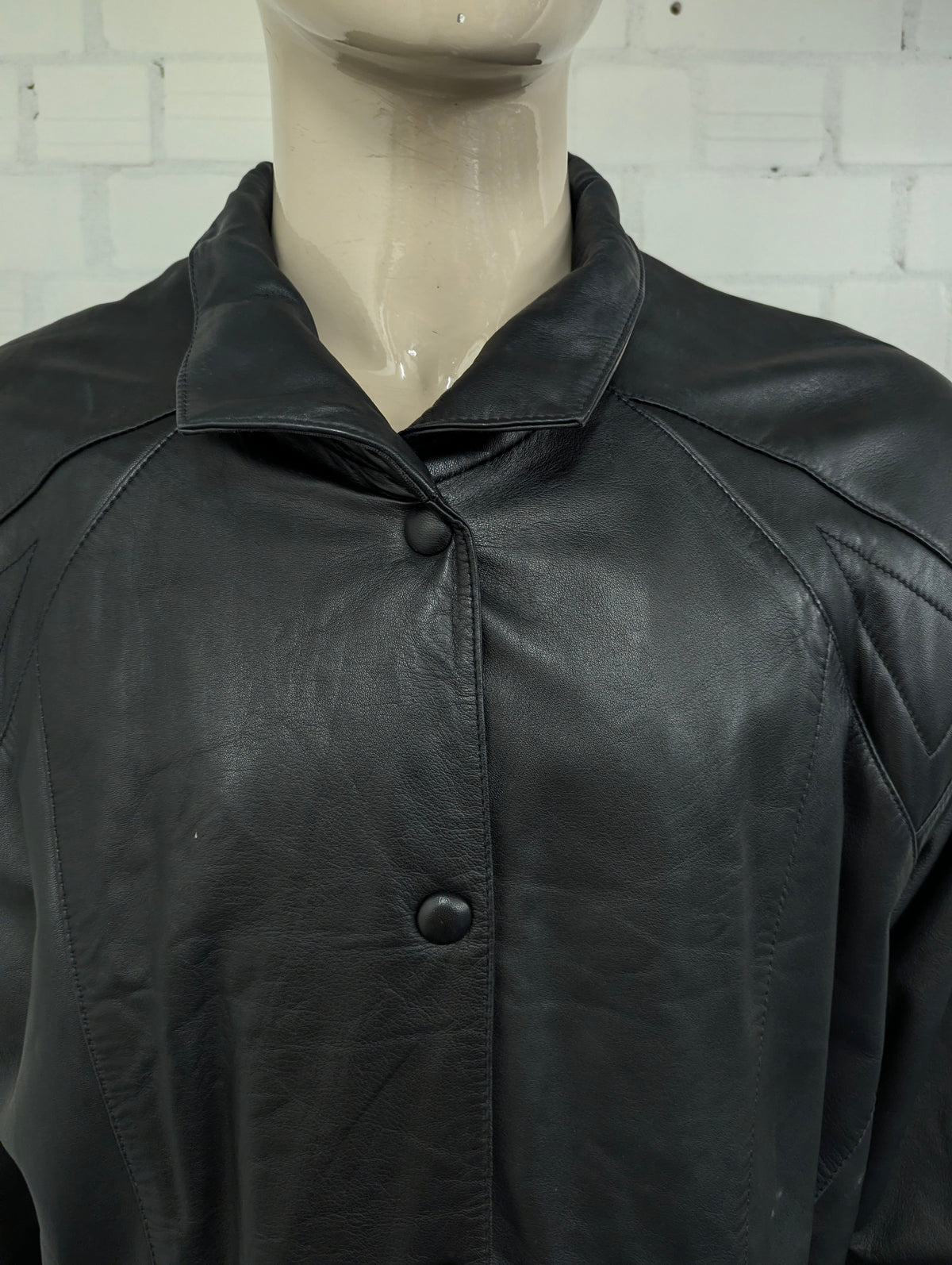 Giacca in pelle super anni '80 con bottoni a pressione e spalline. Di colore nero. Taglia XL. #734.