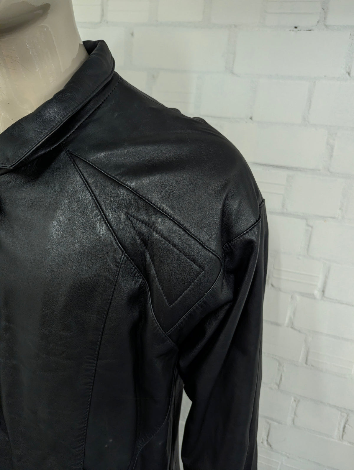 Giacca in pelle super anni '80 con bottoni a pressione e spalline. Di colore nero. Taglia XL. #734.