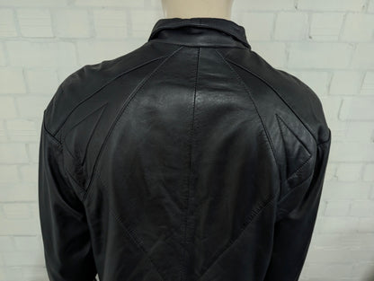 Giacca in pelle super anni '80 con bottoni a pressione e spalline. Di colore nero. Taglia XL. #734.