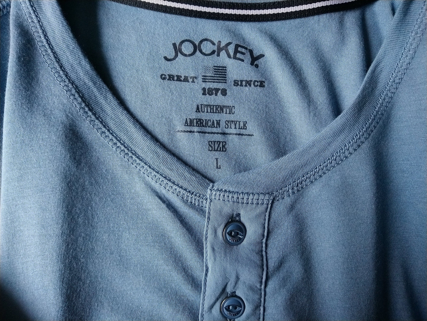 Jockey shirt met knoopjes. Blauw gekleurd. Maat L.