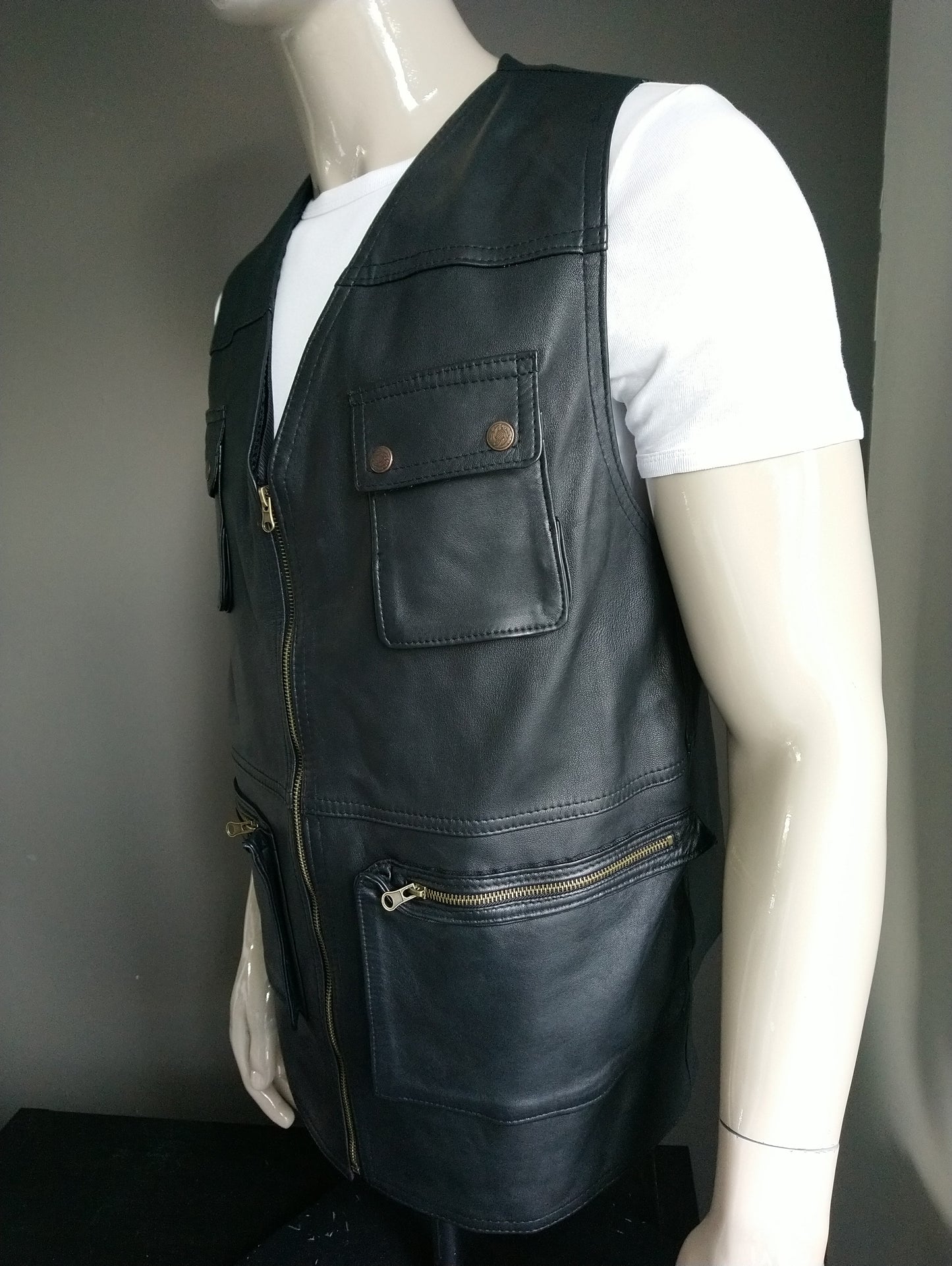 Leather body warmer with bags and zipper. Black colored. Leather back. Size L.