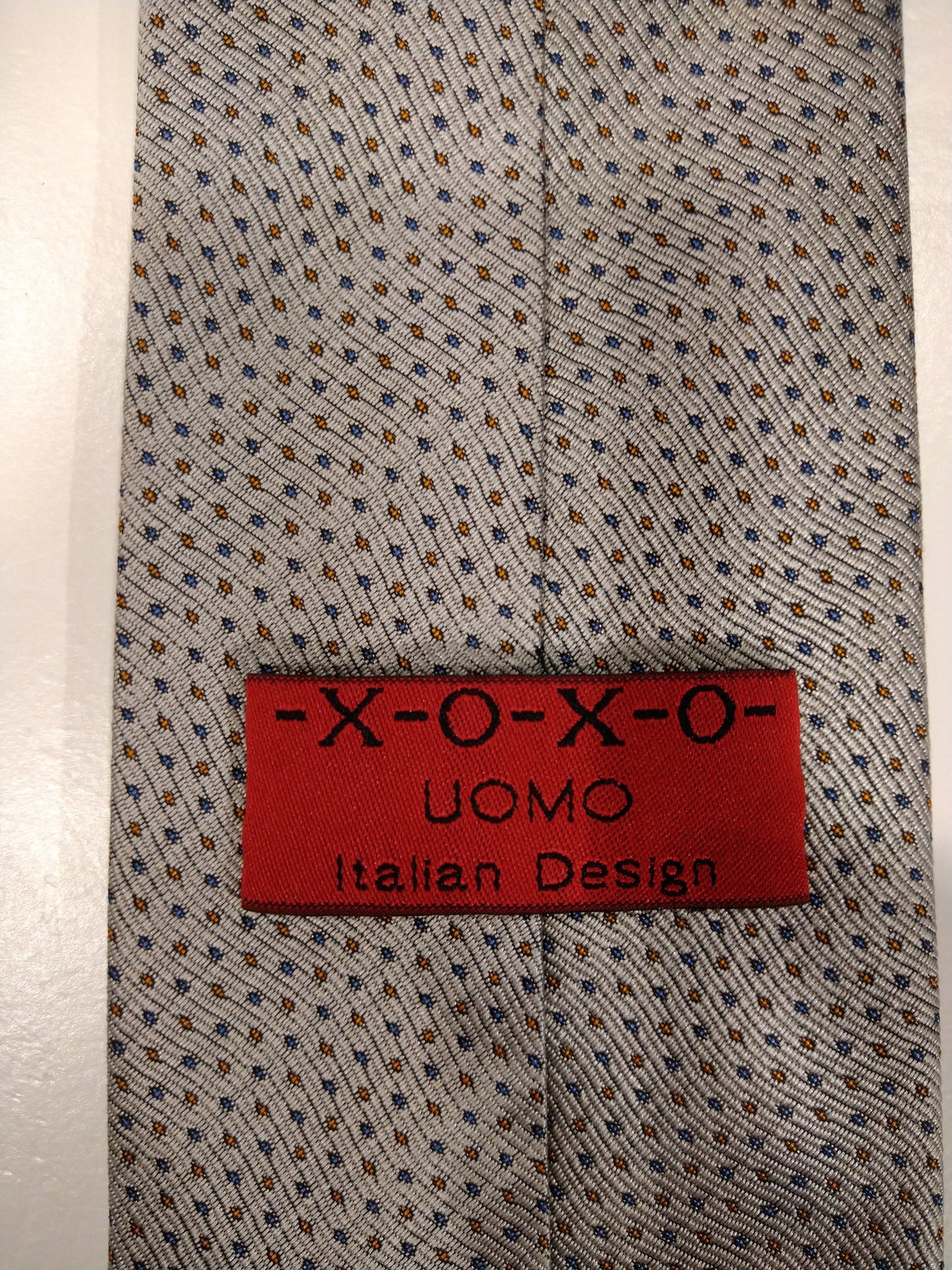 X-O-X-O Uomo Italian Design stropdas. Beige met blauw / bruin bolletjes motief.