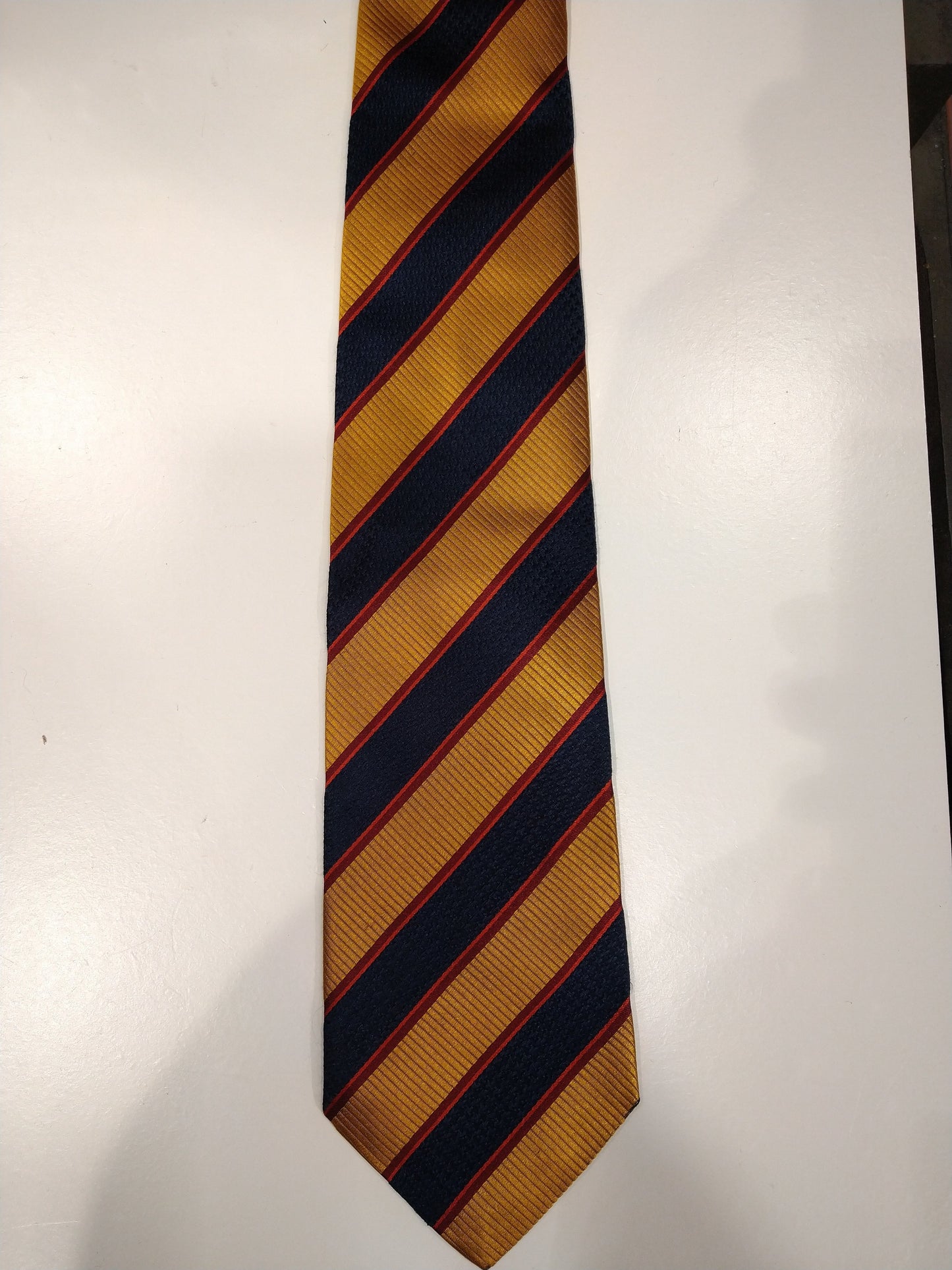 La corbata de seda Scapa o Escocia. Rayas de color rojo azul dorado.