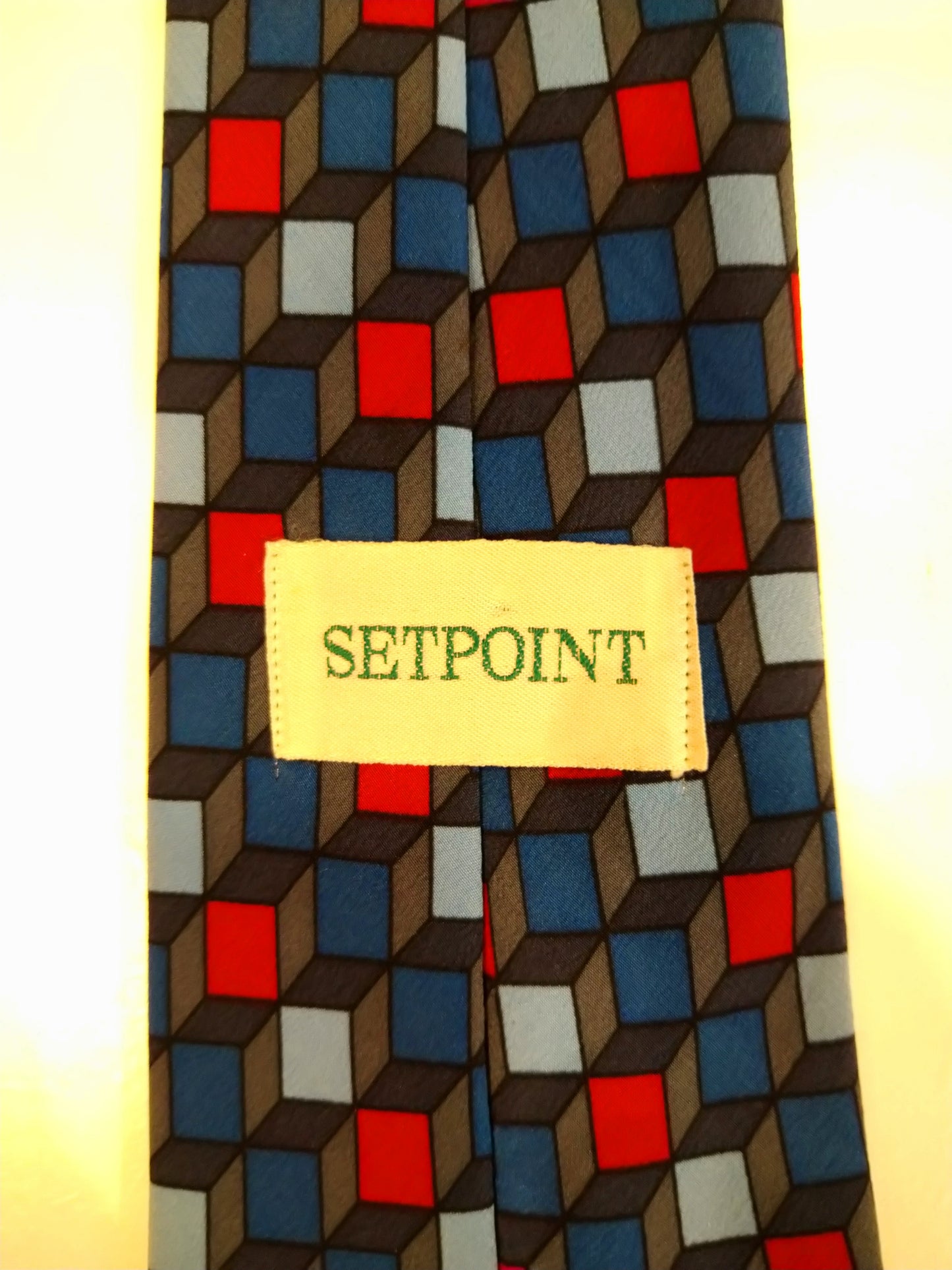 Cravatta setpoint di seta. Motivo a cubetti grigio rosso blu.