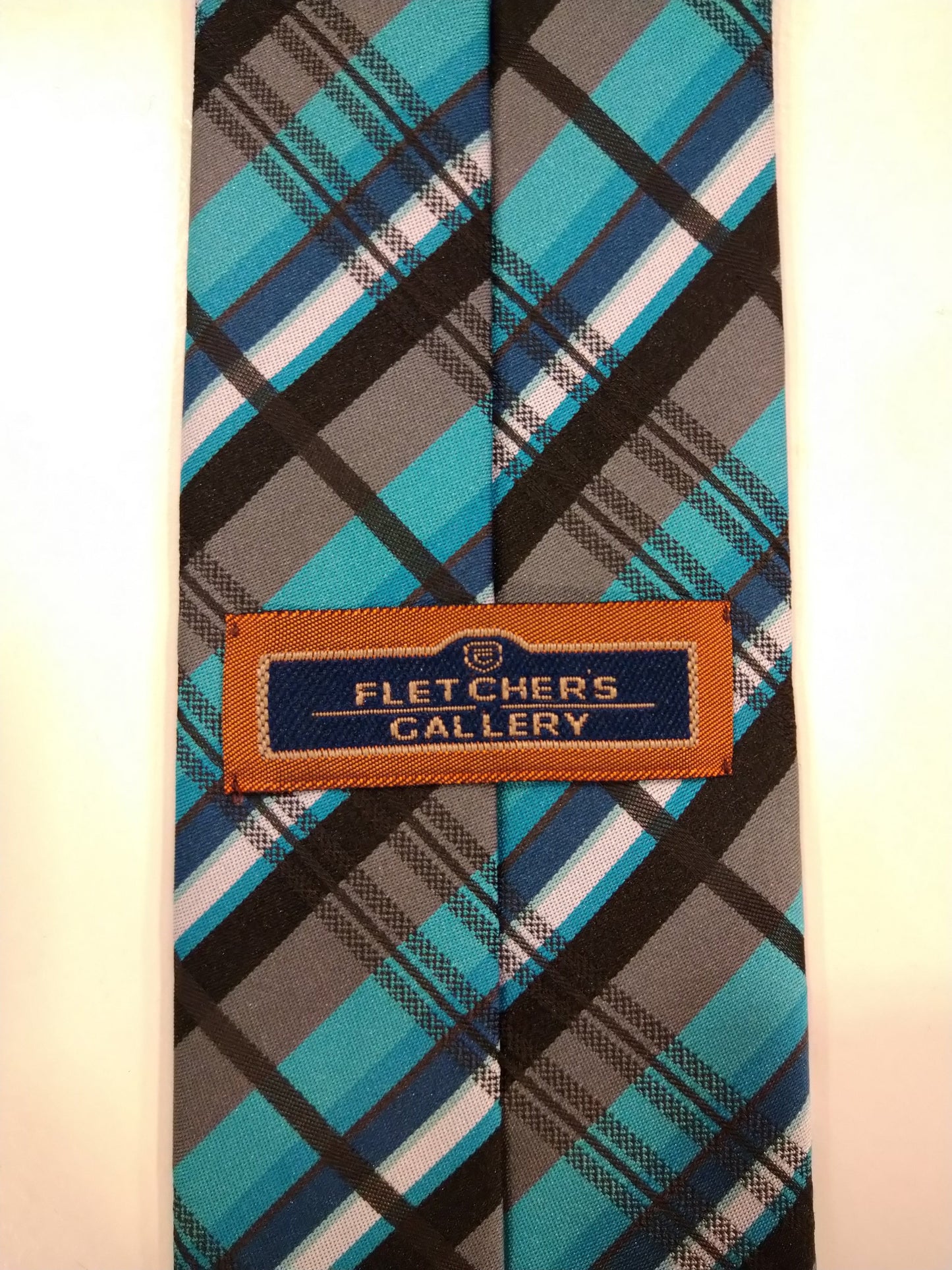 Cravatta in poliestere della galleria Fletchers. Motivo a strisce turchese nera grigia.