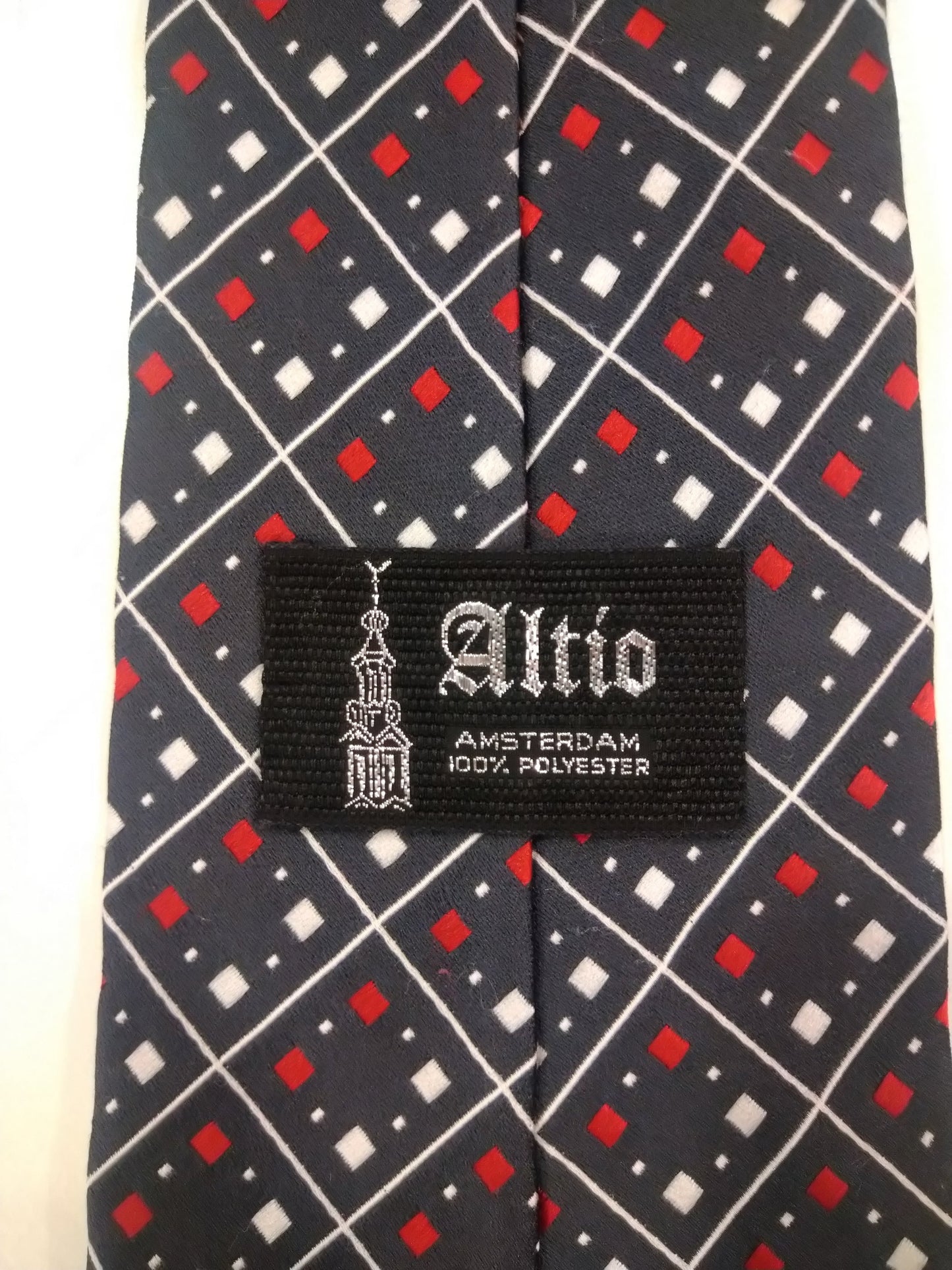 Cravatta in poliestere extra vintage di Altio Amsterdam. Motivo delle palline bianche rosso nero.