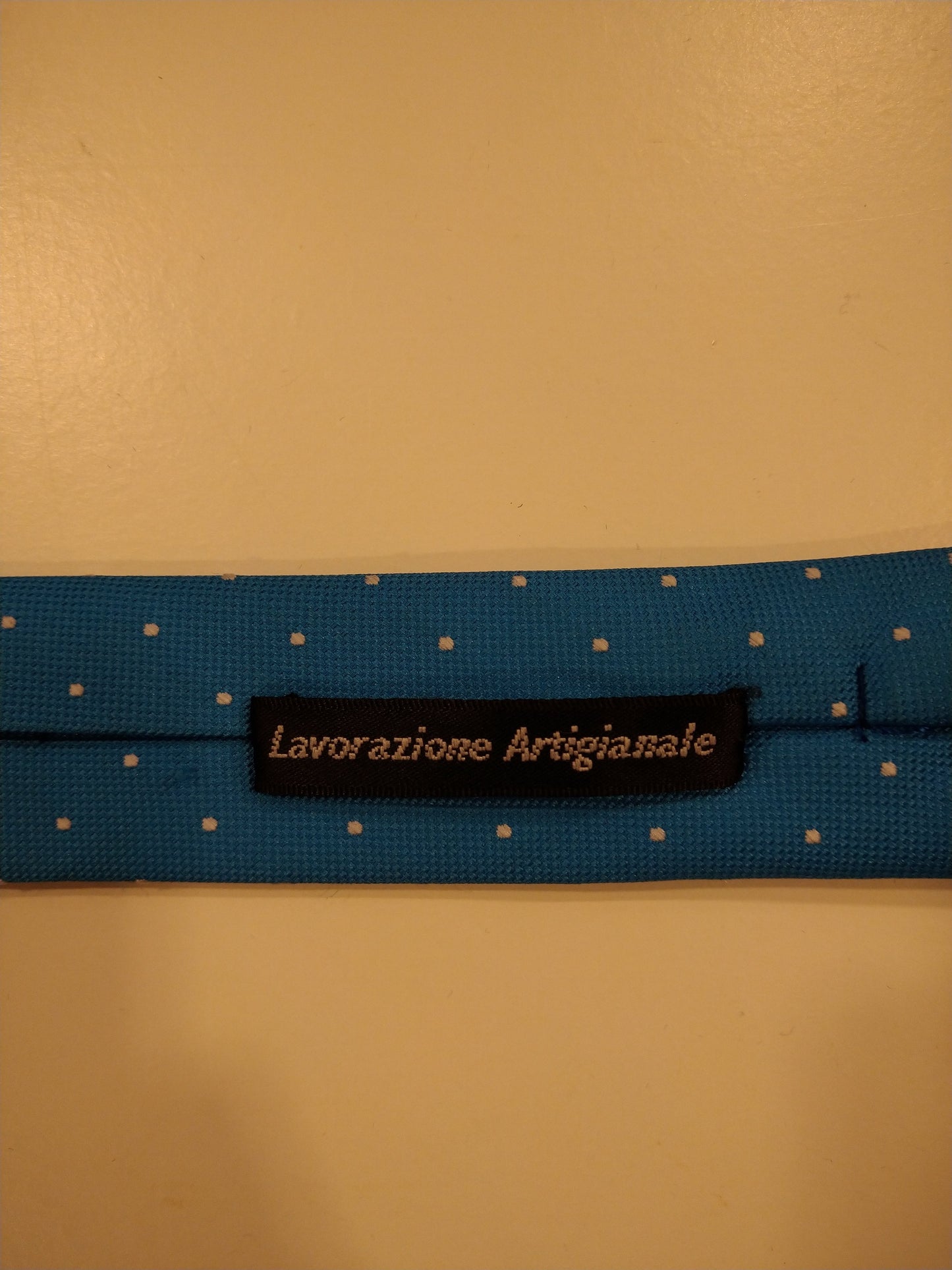 La corbata artigianale de Ladazione. Motivo de punto blanco azul.