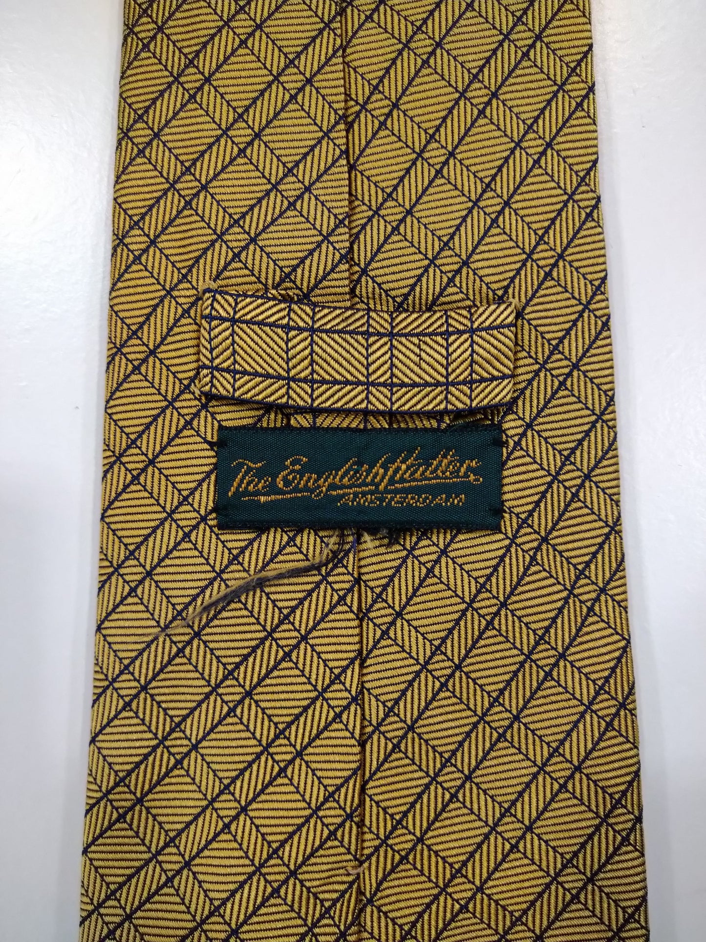 La cravate en soie fabriquée à la main en anglais. Blue or rayé.