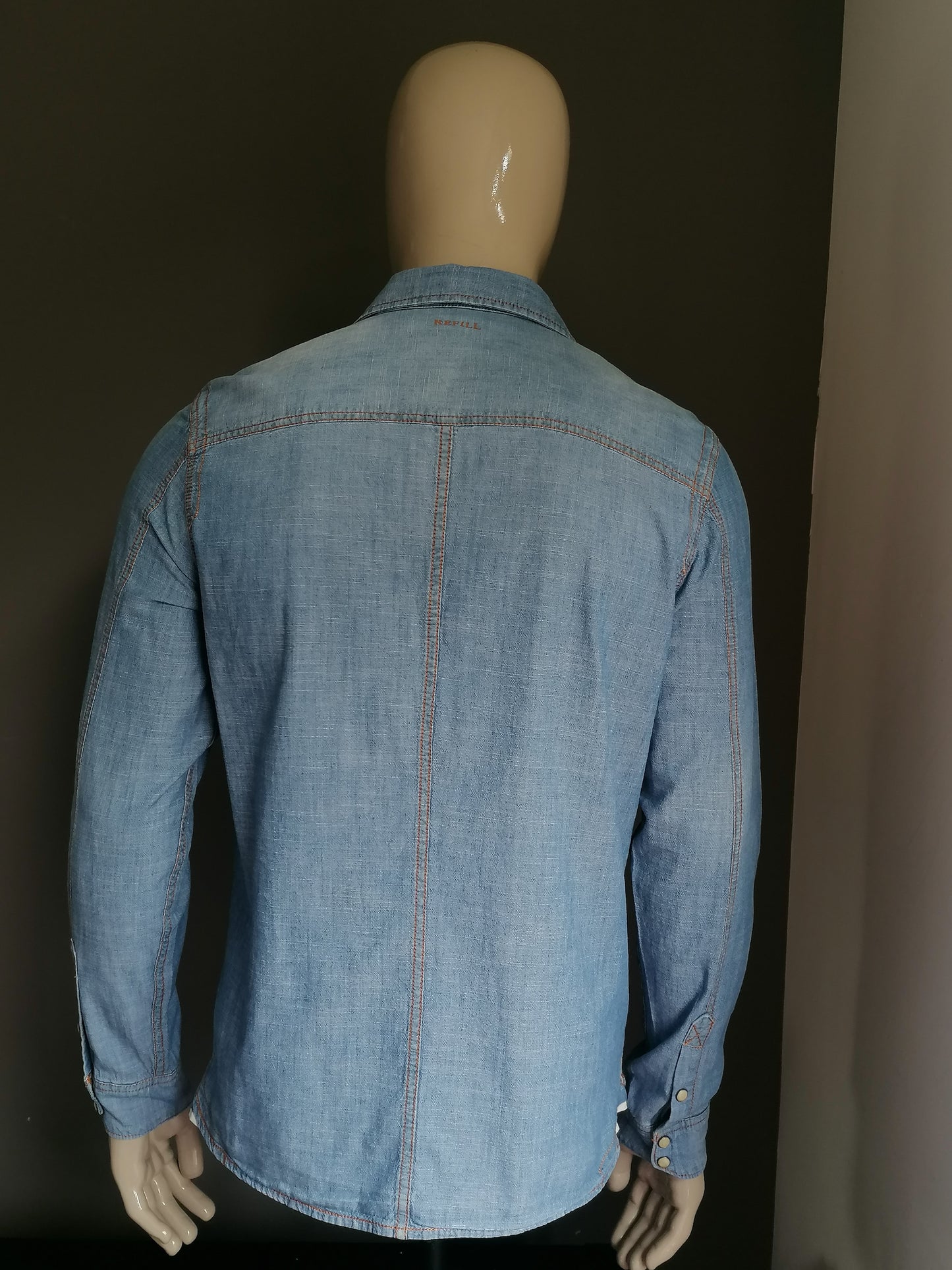 Refill jeans / denim shirt with press studs. Blue colored. Size L.