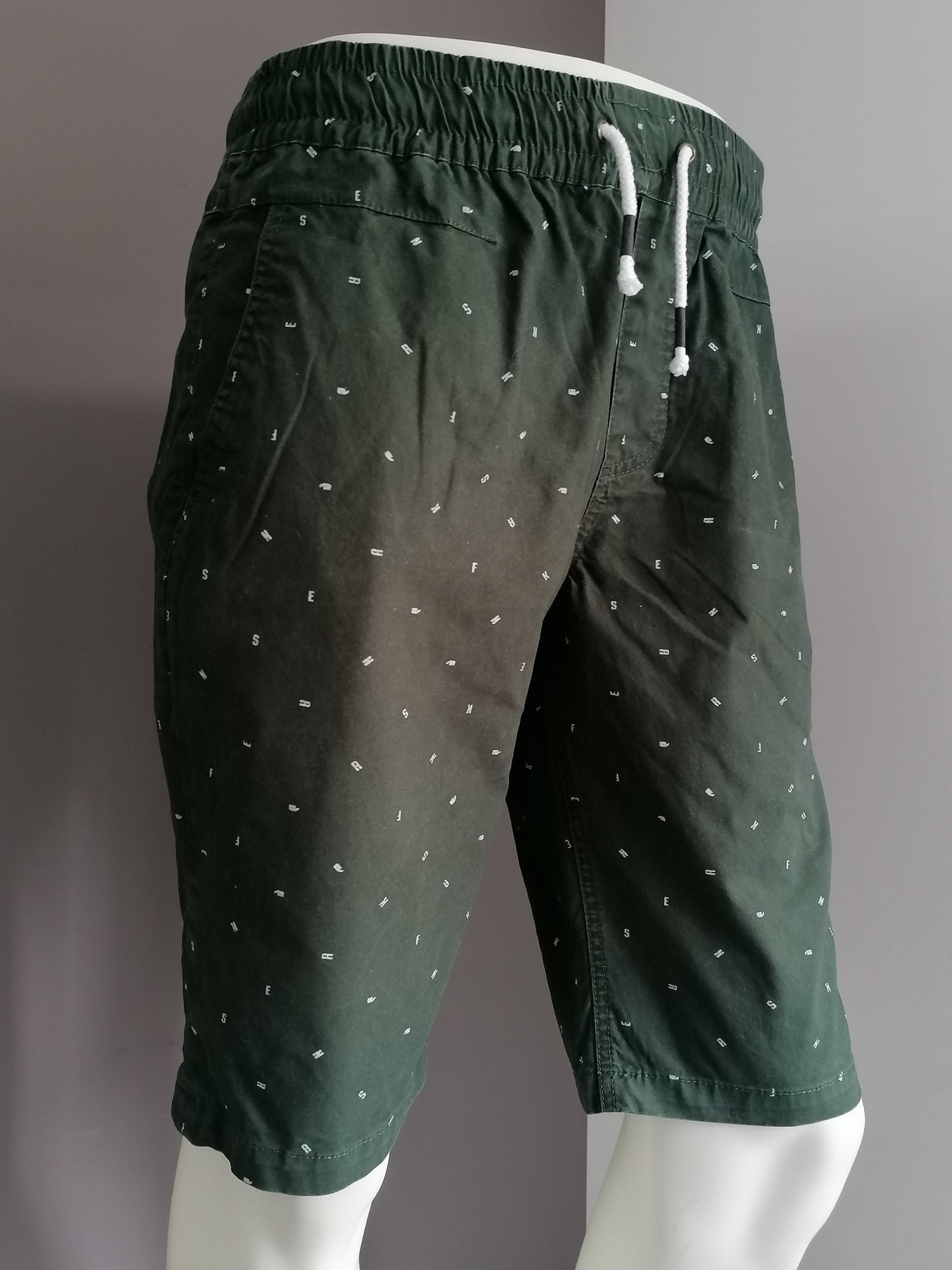 Pantalones cortos de zapatillas con banda elástica. Impresión de letra blanca verde. Talla M.