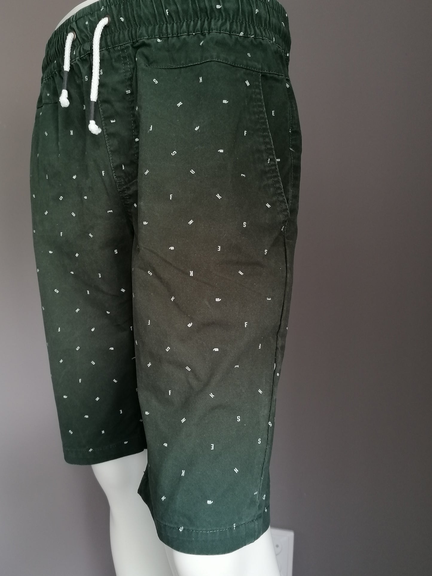 Pantalones cortos de zapatillas con banda elástica. Impresión de letra blanca verde. Talla M.