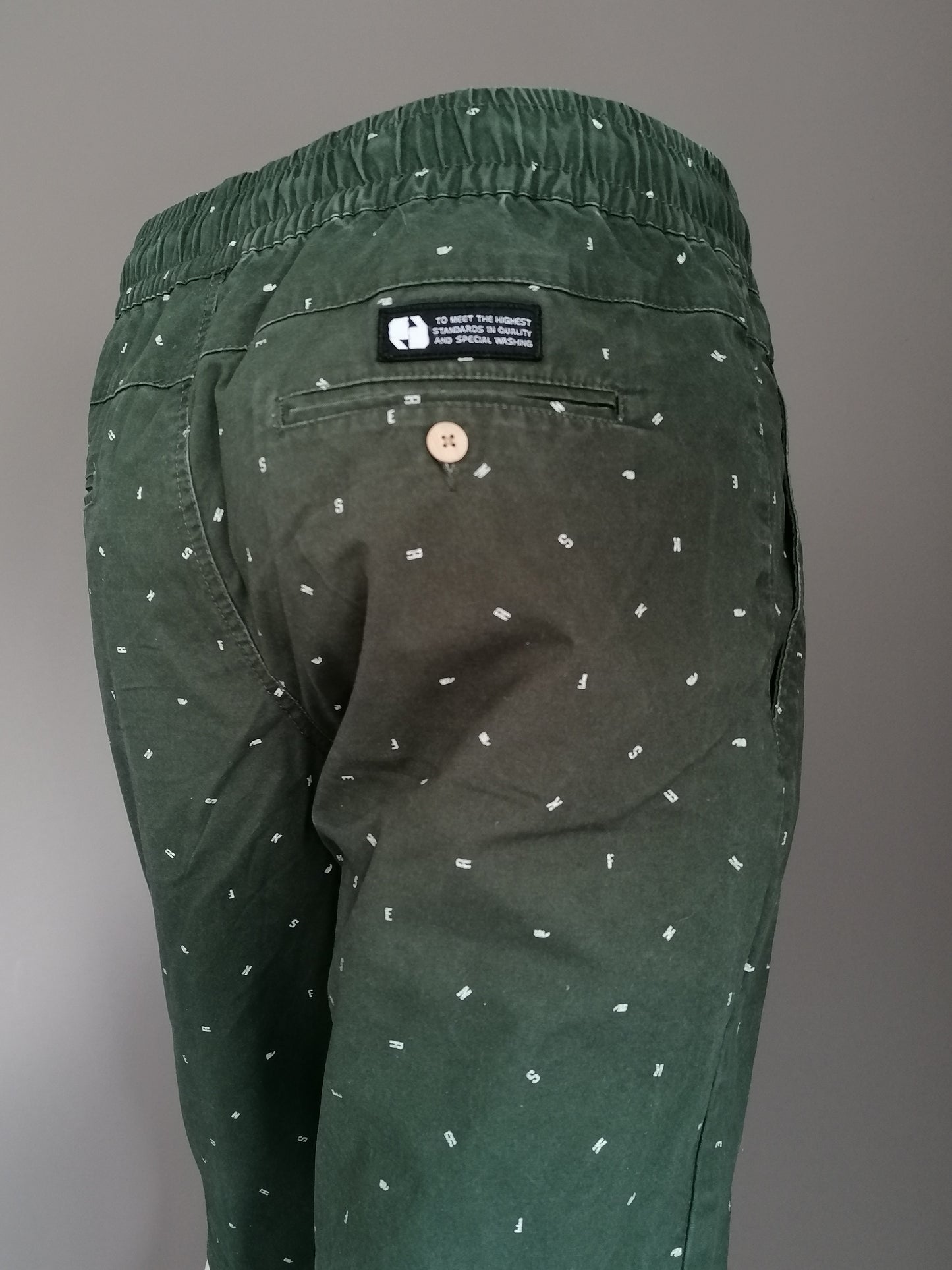 Sneaker Shorts strana con fascia elastica. Stampa di lettera bianca verde. Taglia M.