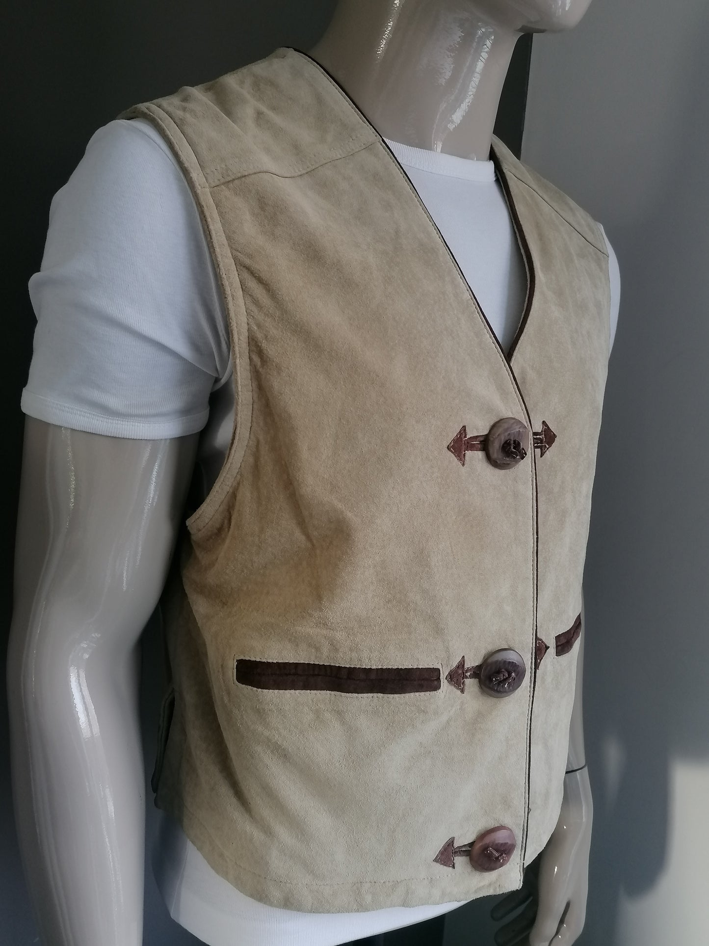Leather / suede waistcoat. Beige brown colored. Large separate buttons. Embroidery rear. Size M.