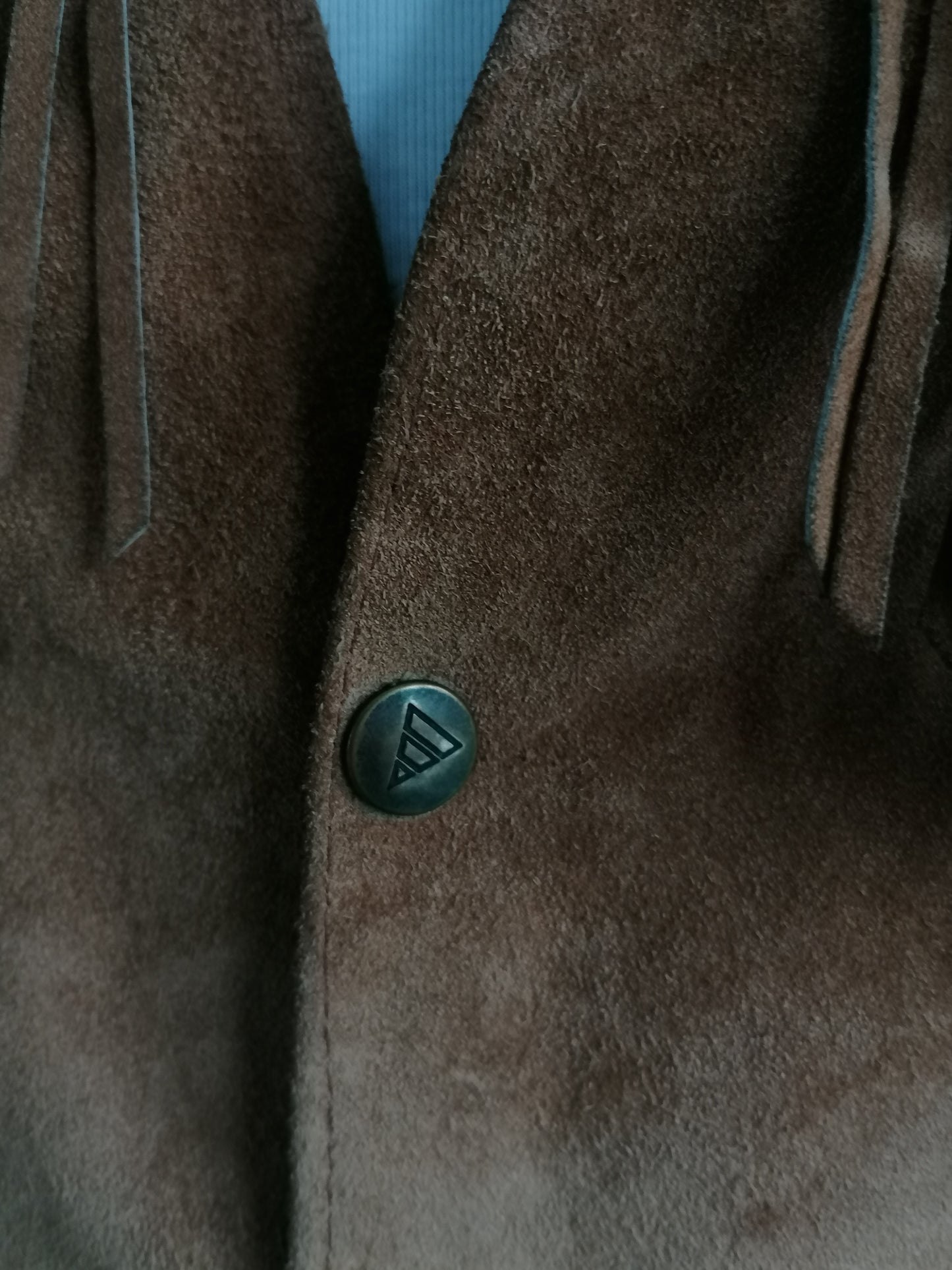 C. Chaleco de gamuza de cuero del condado con franjas y pernos de prensa y acentos de veteros. Color marrón. Talla L.