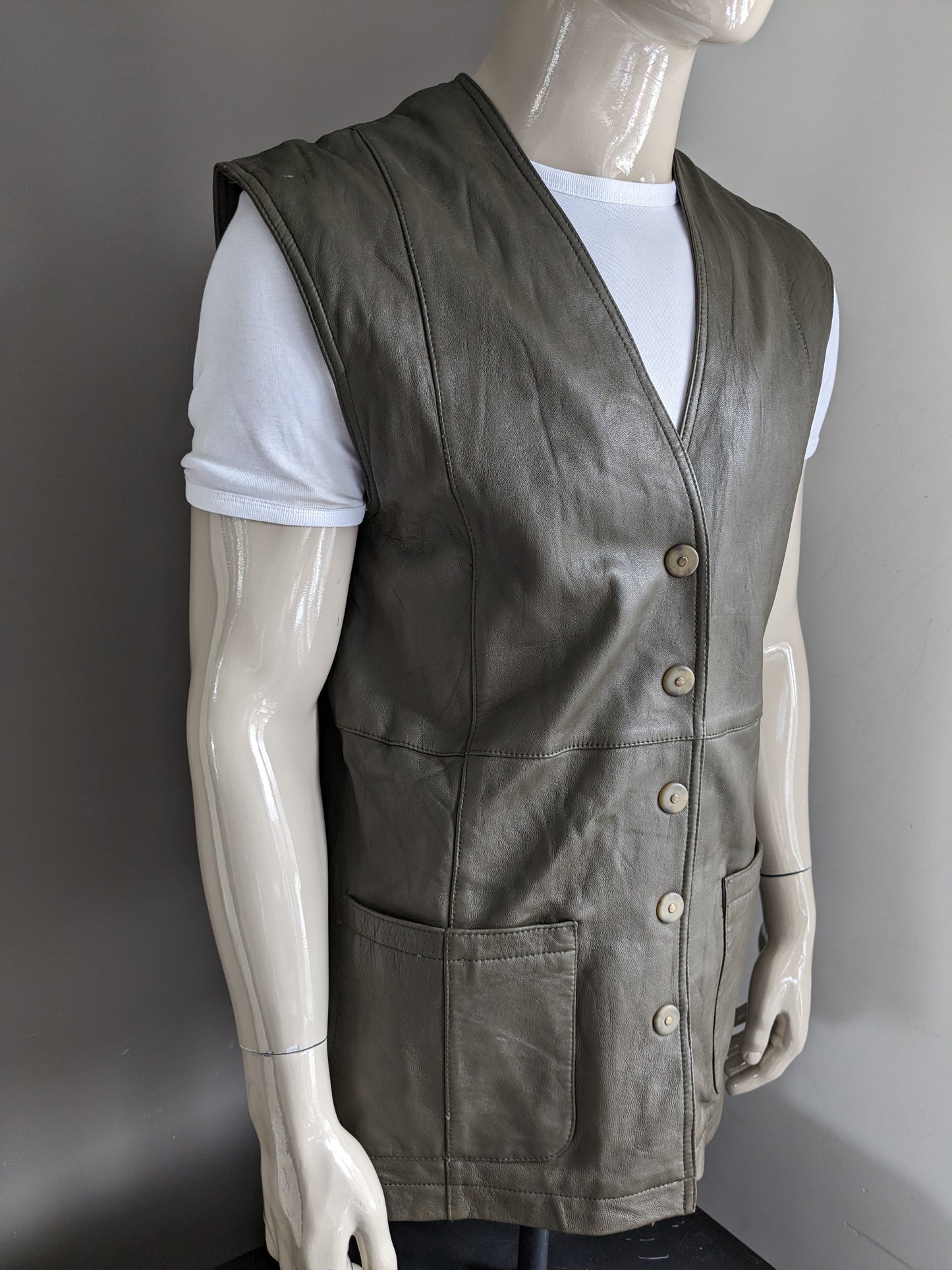 Vintage coda leather waistcoat with press studs. Dark green colored. Size L. Learn back