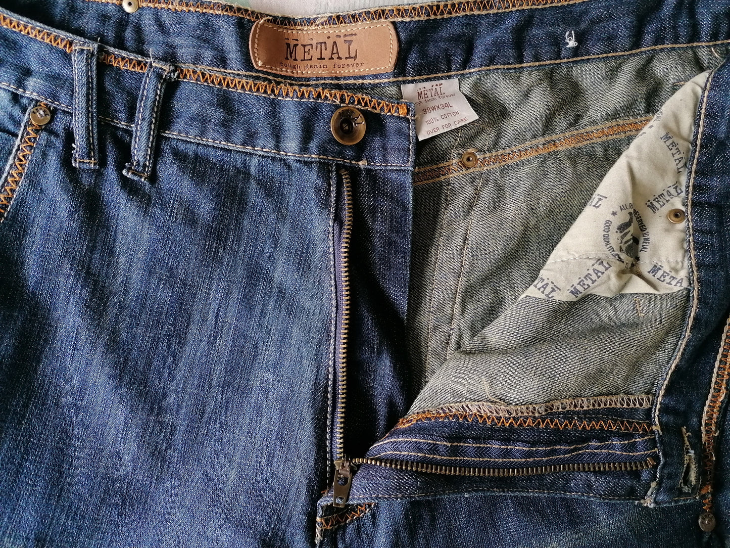 Metal Tough jeans. Blauw met Bruine stiksels. Maat W38 - L34. Wijde broekspijpen.